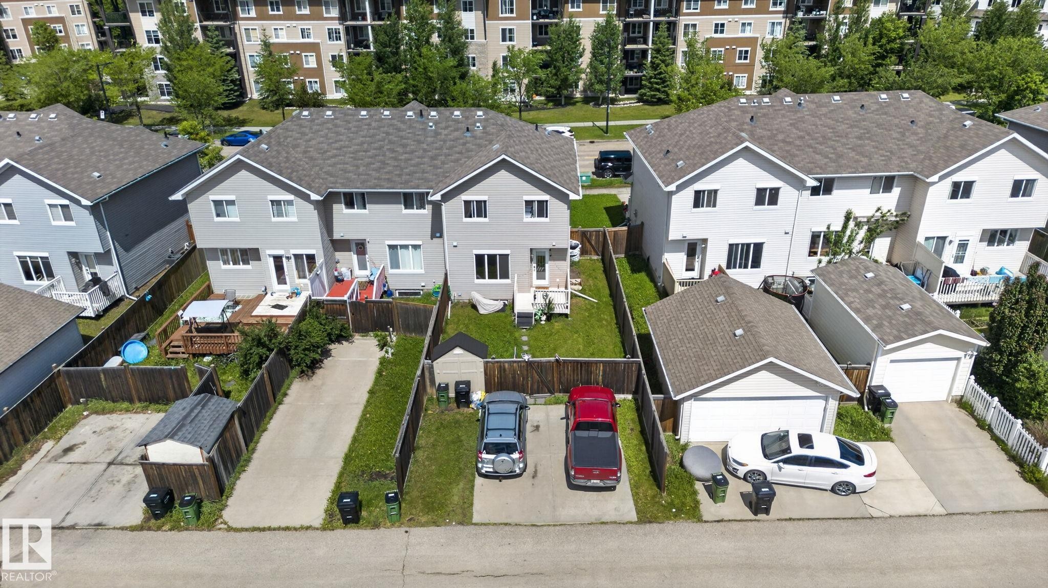 Rear exterior featuring light grey siding, a wood deck, and a fenced yard - 545 Watt Boulevard Sw, Edmonton, AB - Outdoor With Facade