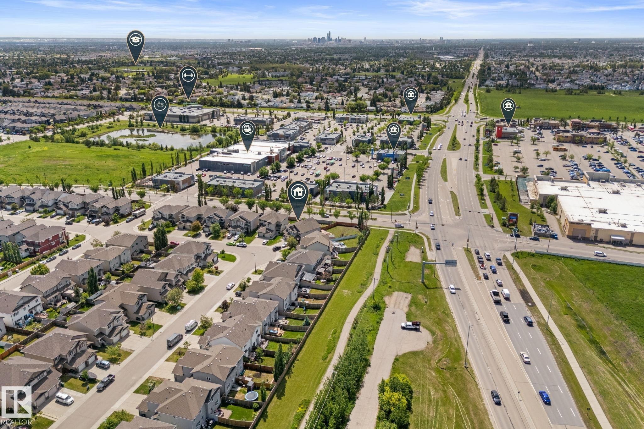 Aerial perspective showcasing a residential neighborhood with numerous detached homes, surrounded by green spaces and commercial buildings - 12523 171 Avenue, Edmonton, AB