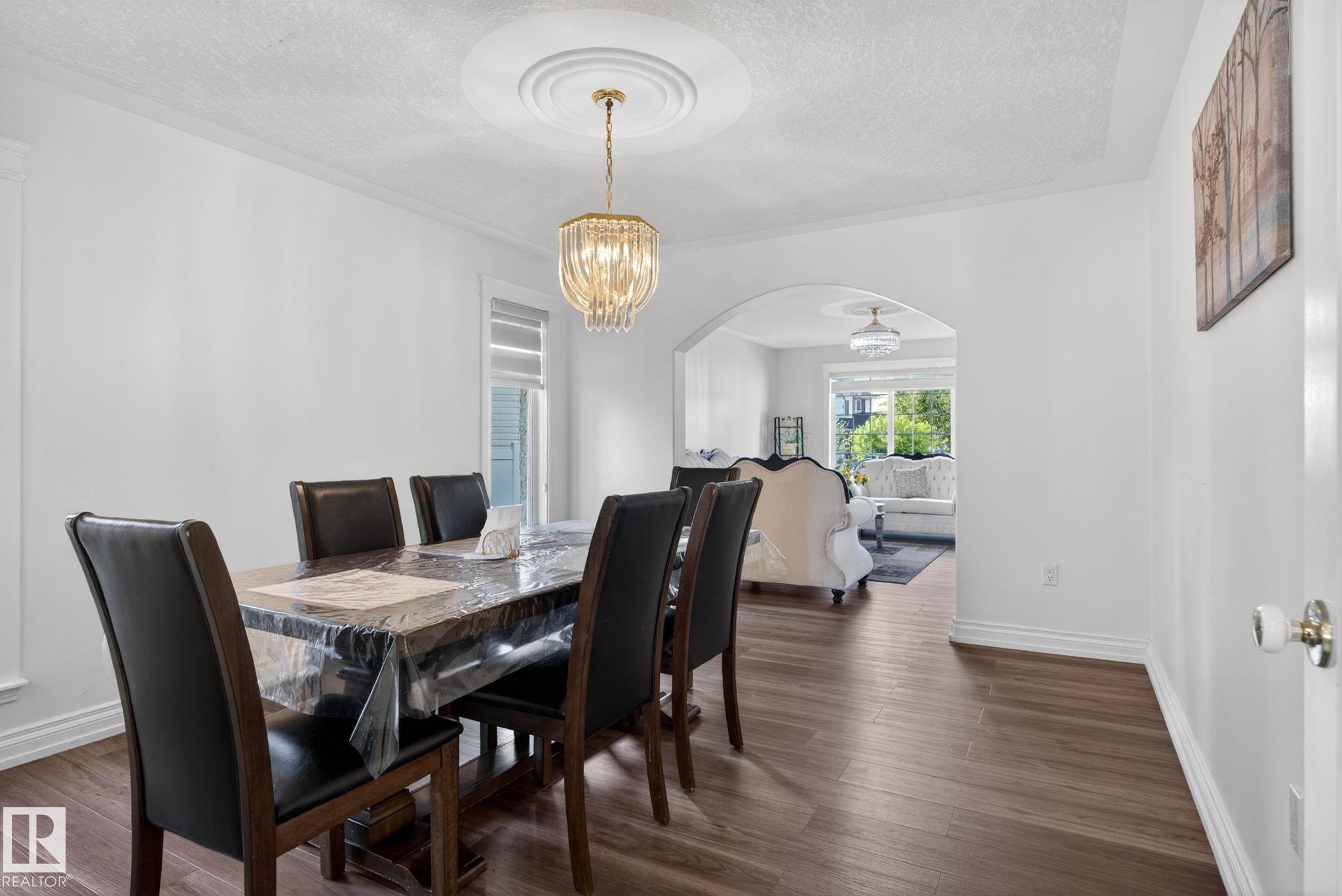 Dining area featuring wood-finish flooring, an arched doorway, and crown molding - 4615 43A Avenue, Edmonton, AB - Indoor Photo Showing Dining Room
