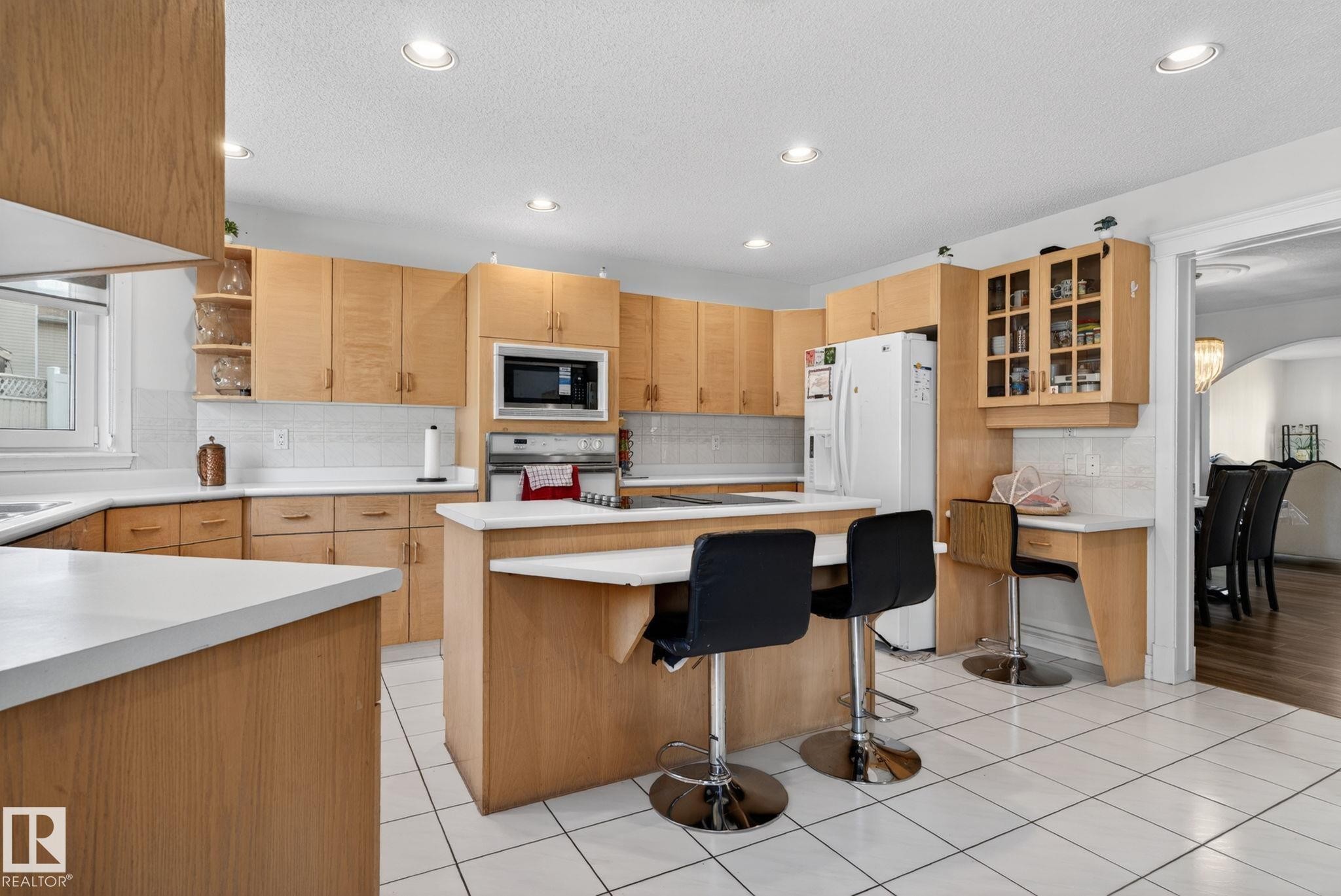 Kitchen featuring wood cabinetry, white countertops, built-in microwave, and tile flooring - 4615 43A Avenue, Edmonton, AB - Indoor Photo Showing Kitchen