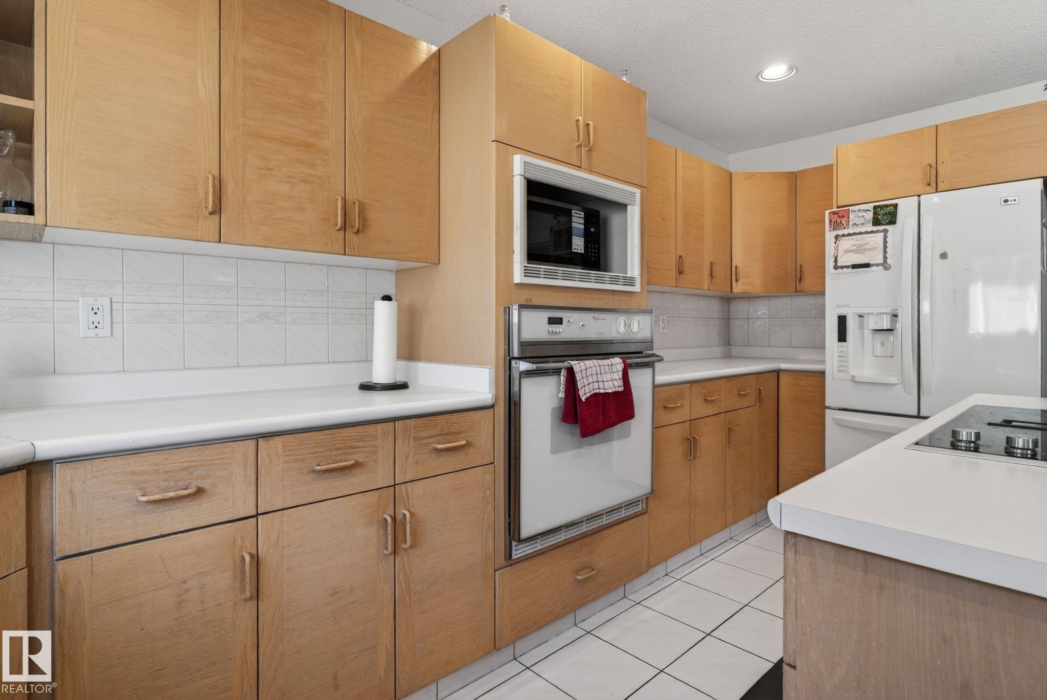 Kitchen featuring light wood cabinetry, white countertops, a built-in microwave, a wall oven, and tile flooring - 4615 43A Avenue, Edmonton, AB - Indoor Photo Showing Kitchen
