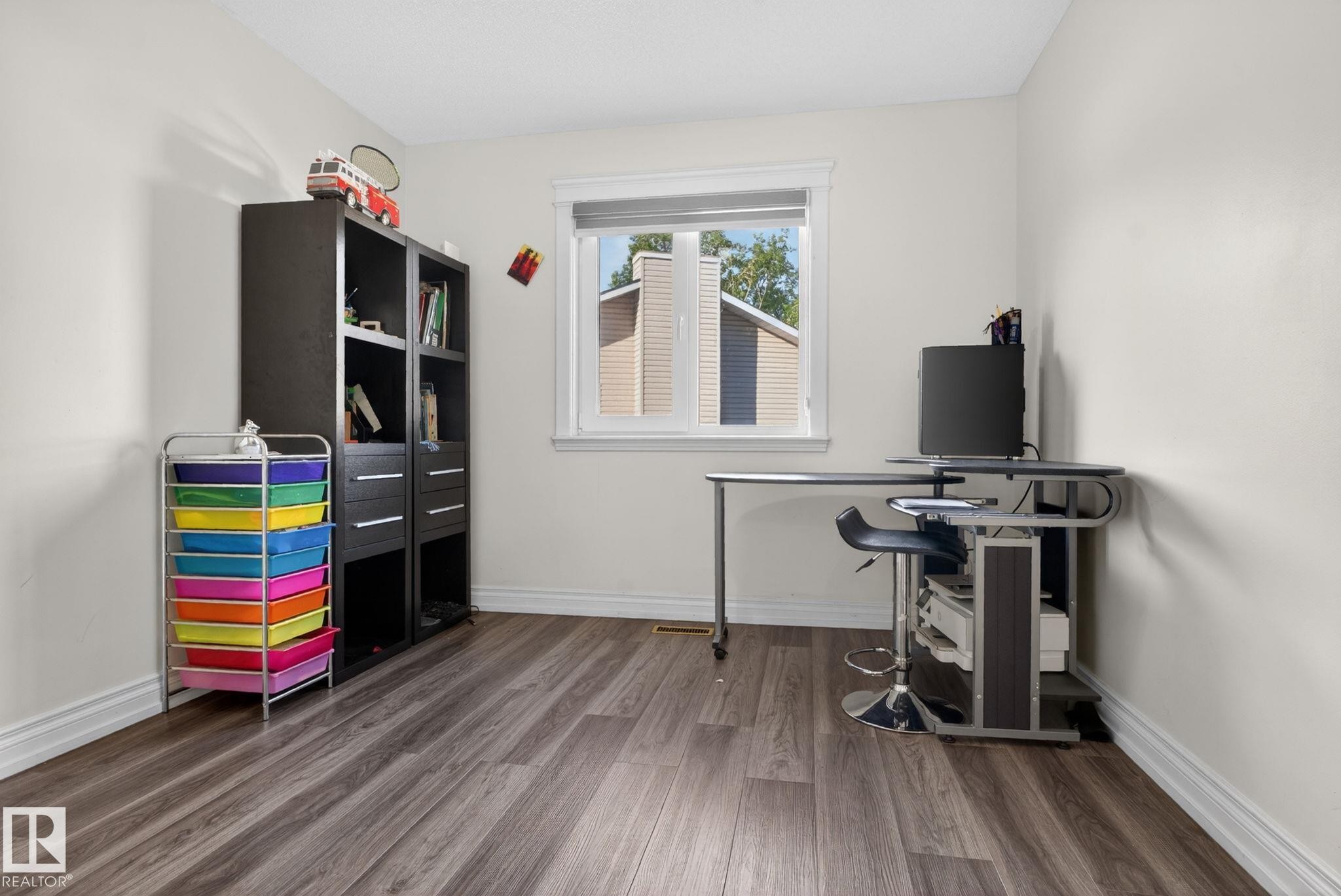 Room featuring wood-finish flooring, white walls, and bright trim - 4615 43A Avenue, Edmonton, AB - Indoor Photo Showing Office