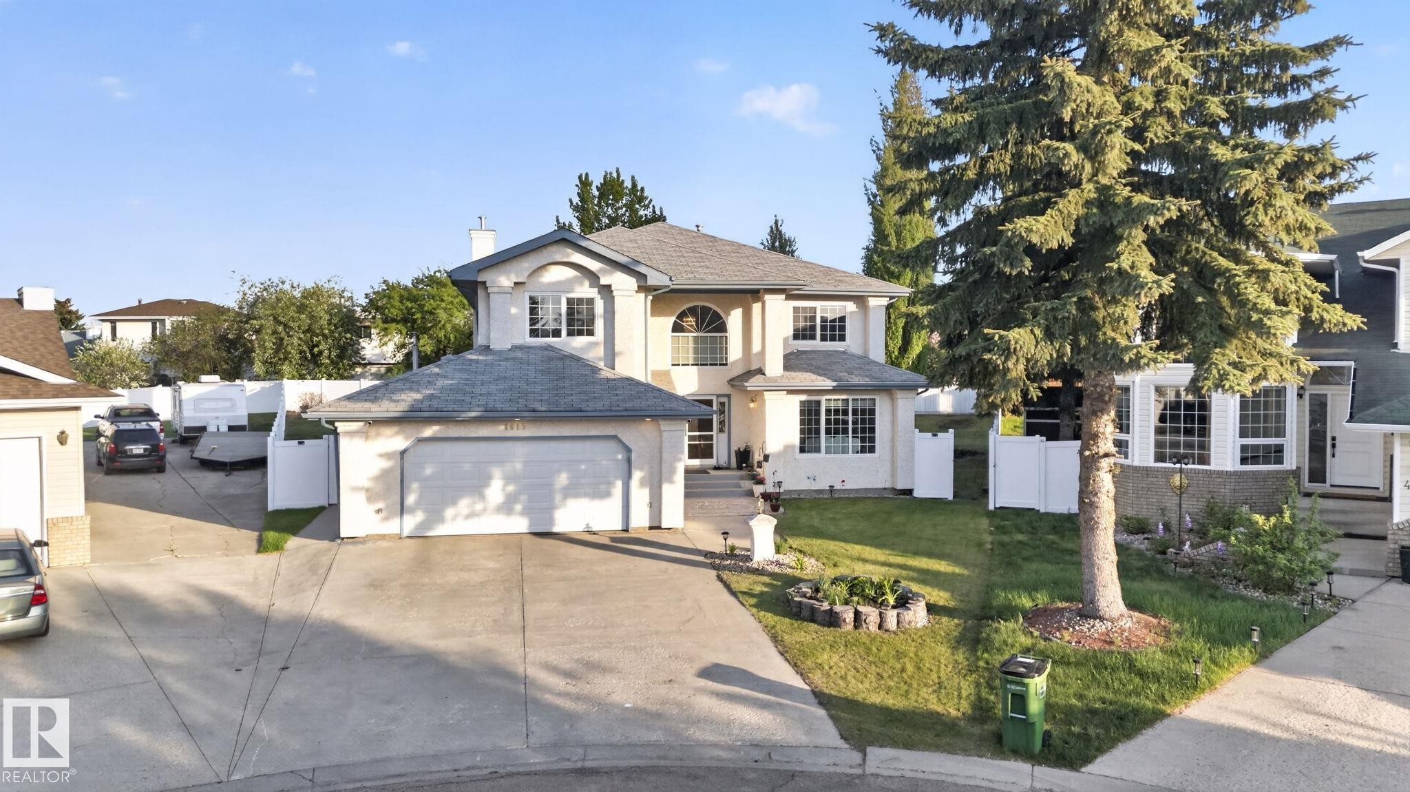 Exterior featuring light-colored stucco, a multi-car driveway, a two-car attached garage, and a separate single-car attached garage - 4615 43A Avenue, Edmonton, AB - Outdoor