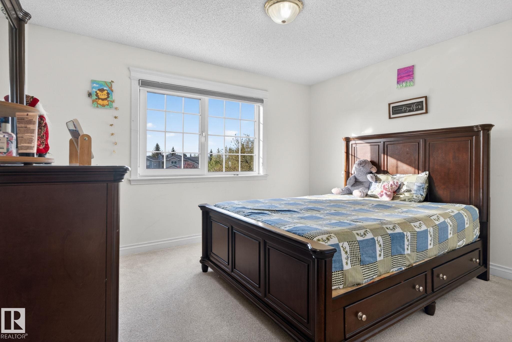 Carpeted bedroom with neutral wall paint, white trim, and a multi-pane window - 4615 43A Avenue, Edmonton, AB - Indoor Photo Showing Bedroom