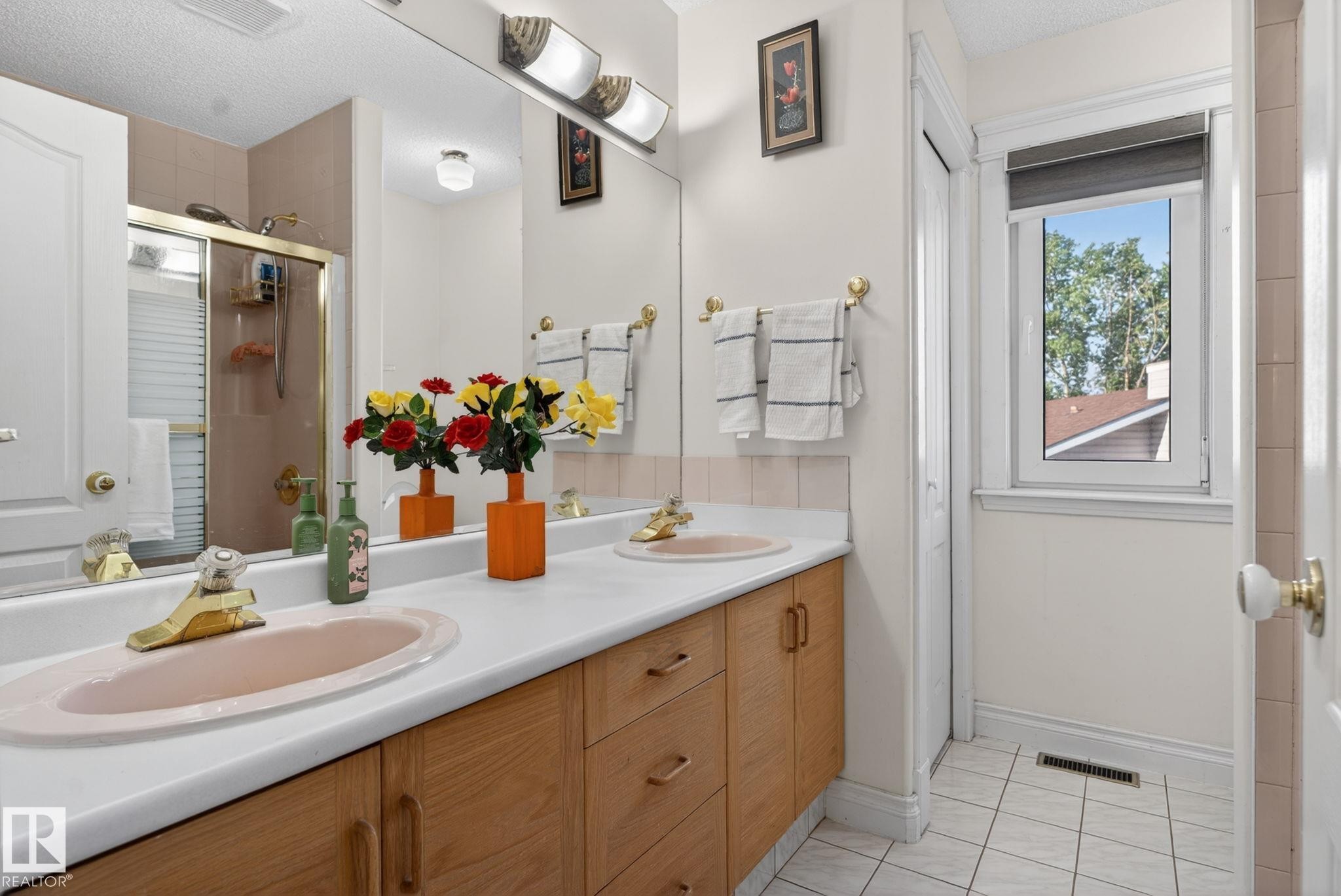Bathroom featuring a double vanity with wood-finish cabinetry, a large mirror, and overhead strip lighting - 4615 43A Avenue, Edmonton, AB - Indoor Photo Showing Bathroom