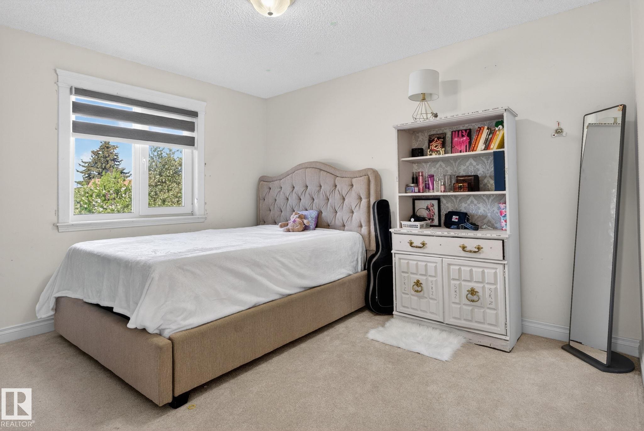 Carpeted room with a single window featuring horizontal blinds - 4615 43A Avenue, Edmonton, AB - Indoor Photo Showing Bedroom