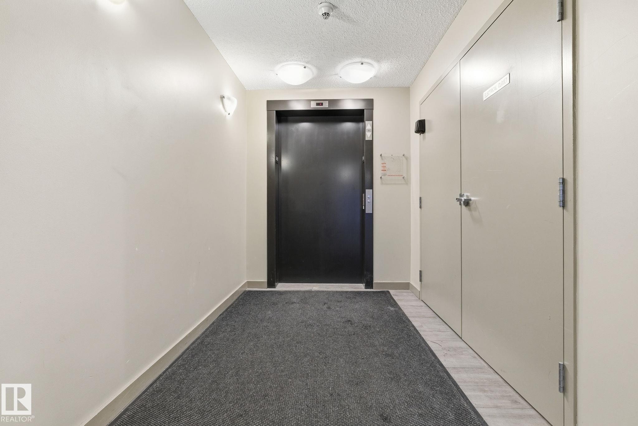 Elevator access featuring a dark finished door, neutral wall tones, and recessed lighting - 424 1510 Watt Drive, Edmonton, AB