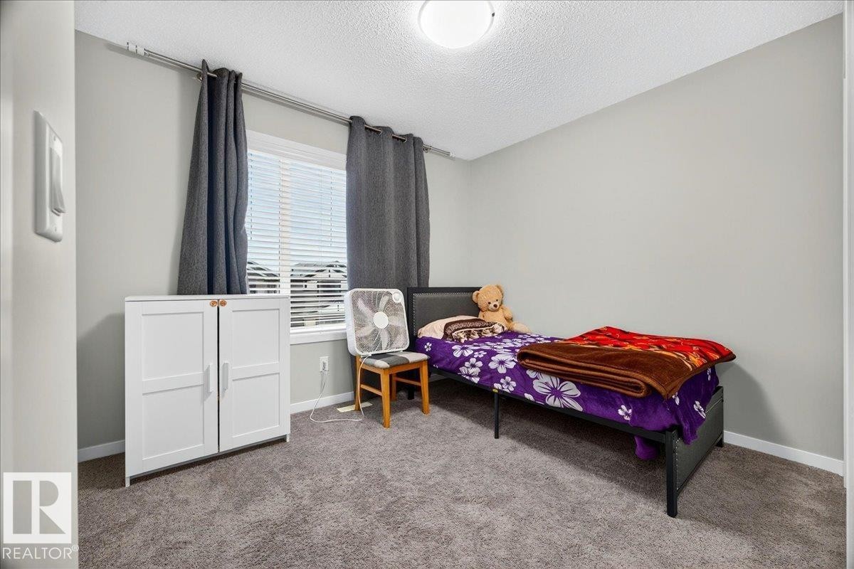 Neutral-toned wall paint and carpet flooring create a cohesive aesthetic in this room - 1187 Cy Becker Road, Edmonton, AB