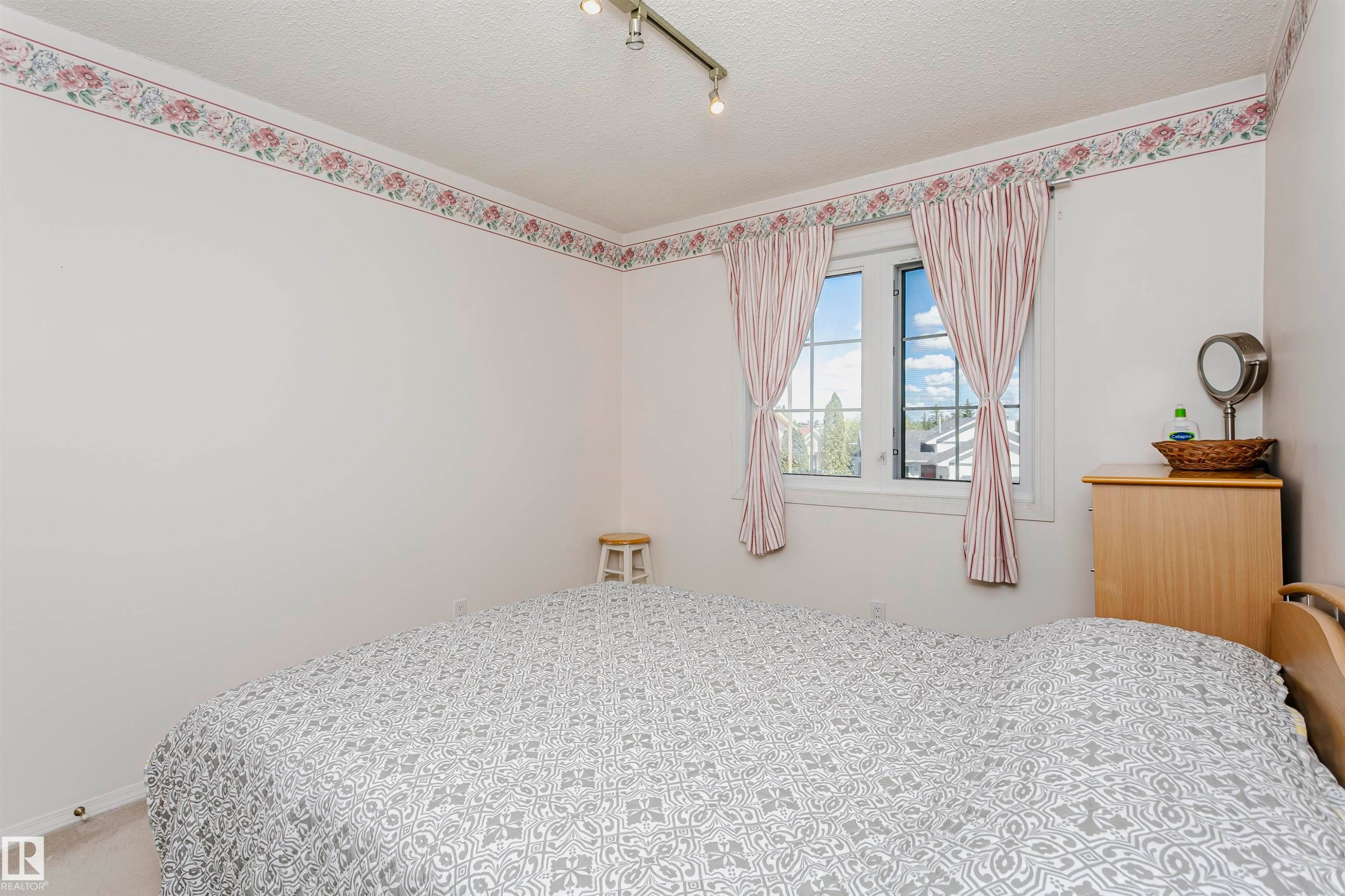 Windowed interior space featuring light-colored walls and a textured ceiling - 11023 11A Avenue Nw, Edmonton, AB - Indoor Photo Showing Bedroom