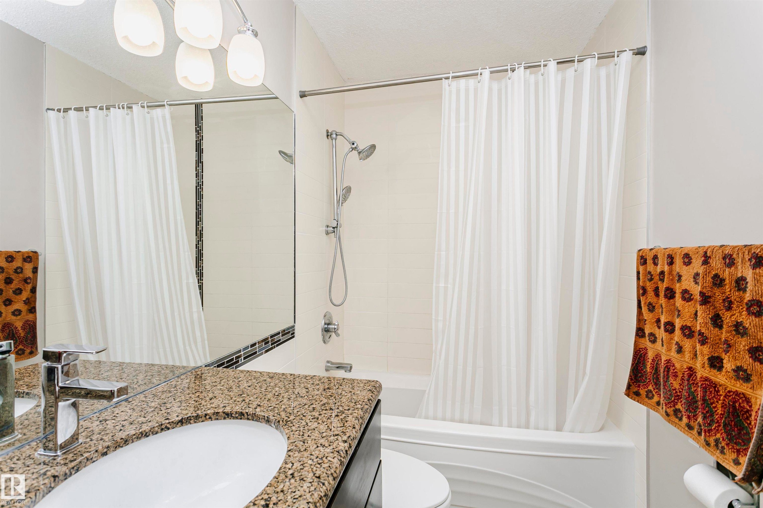 Bathroom featuring a vanity with a countertop, an undermount sink, and a chrome faucet - 11023 11A Avenue Nw, Edmonton, AB - Indoor Photo Showing Bathroom