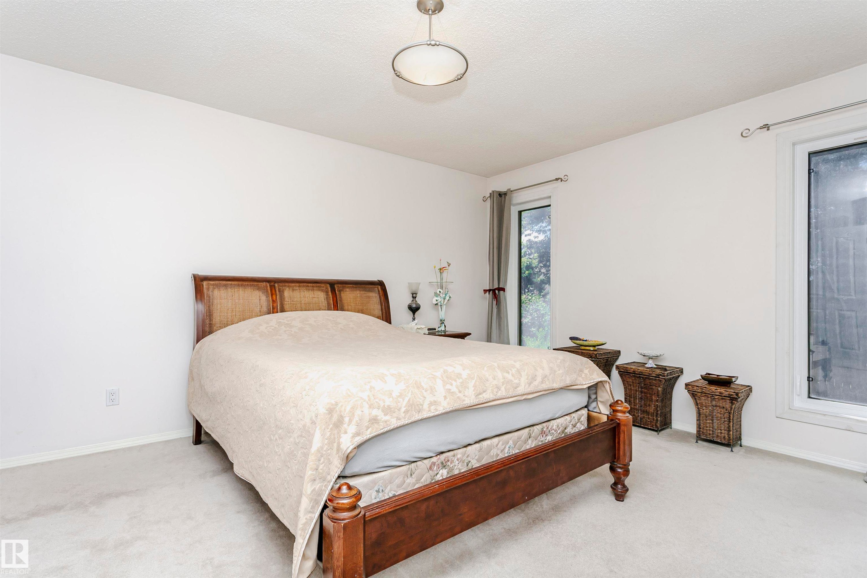 Carpeted bedroom featuring multiple windows, a ceiling-mounted light fixture, and neutral wall paint - 11023 11A Avenue Nw, Edmonton, AB - Indoor Photo Showing Bedroom