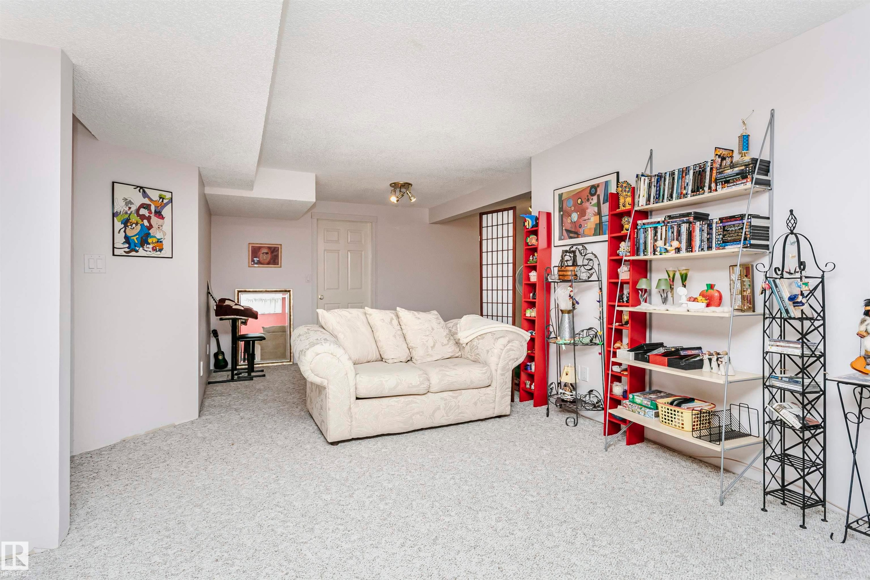 Carpeted recreation room with white walls, recessed ceiling, and a white paneled door - 11023 11A Avenue Nw, Edmonton, AB - Indoor