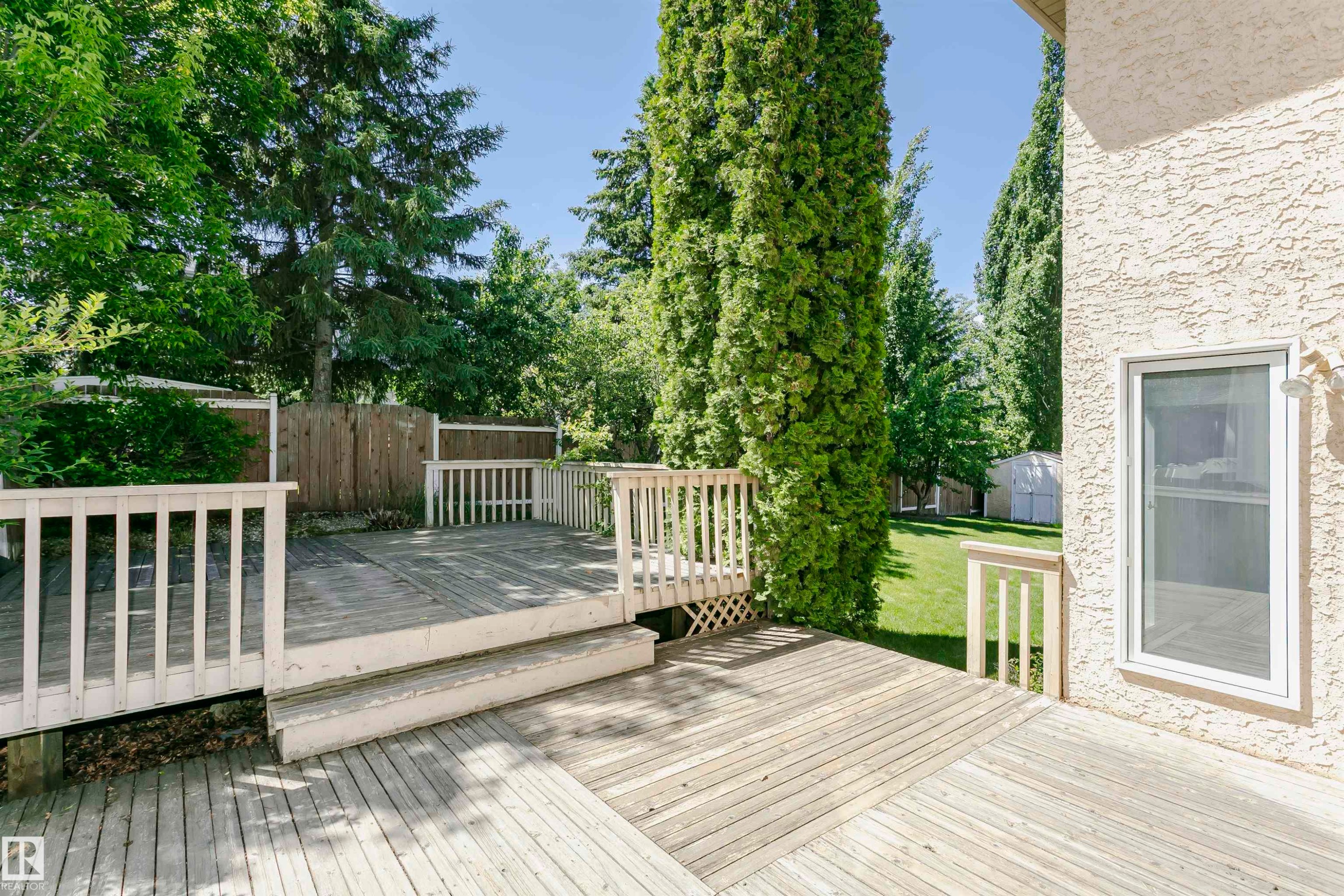 Multi-level wood deck with white railings - 11023 11A Avenue Nw, Edmonton, AB - Outdoor With Deck Patio Veranda With Exterior