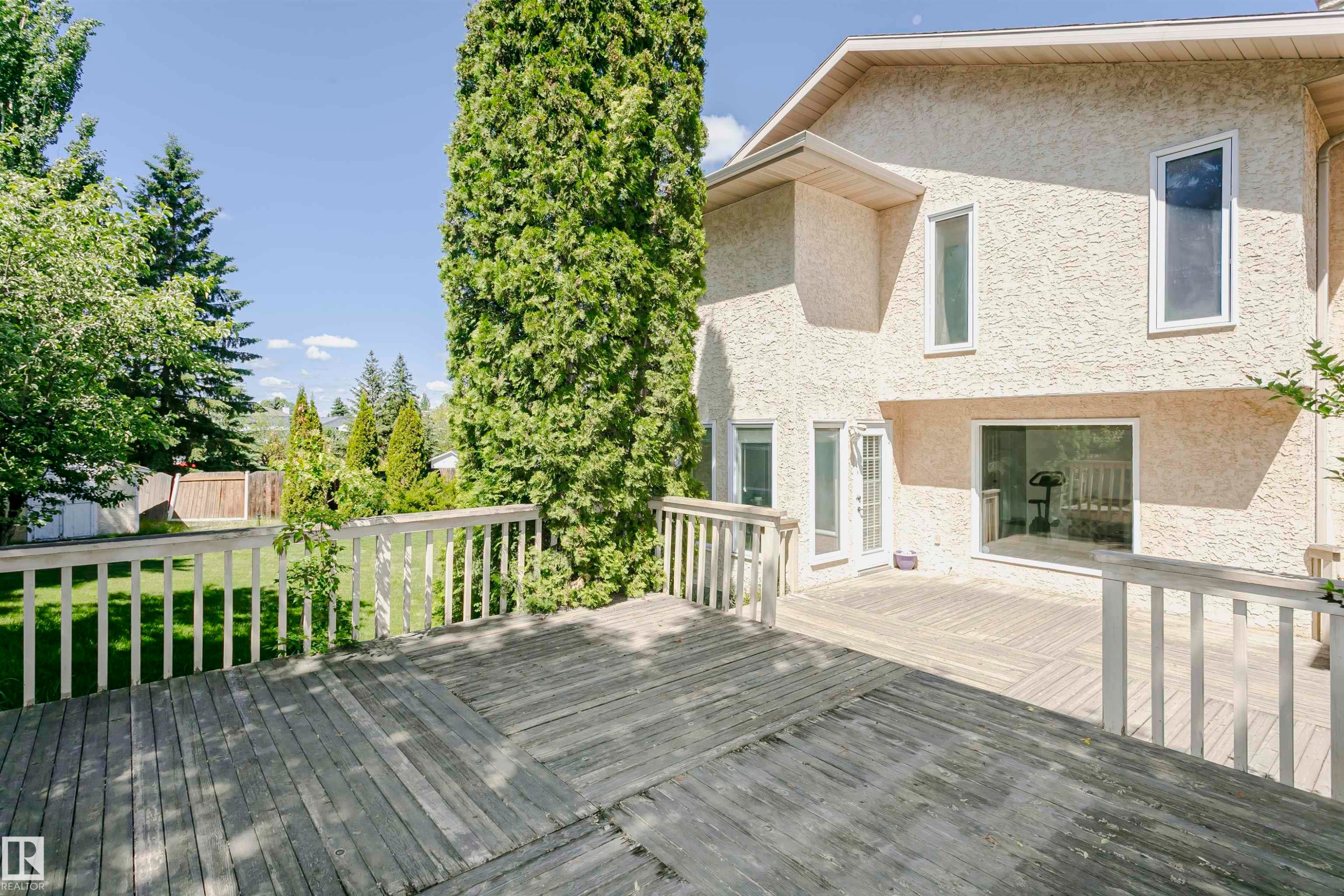 Multi-level wood deck with white railings - 11023 11A Avenue Nw, Edmonton, AB - Outdoor With Deck Patio Veranda With Exterior