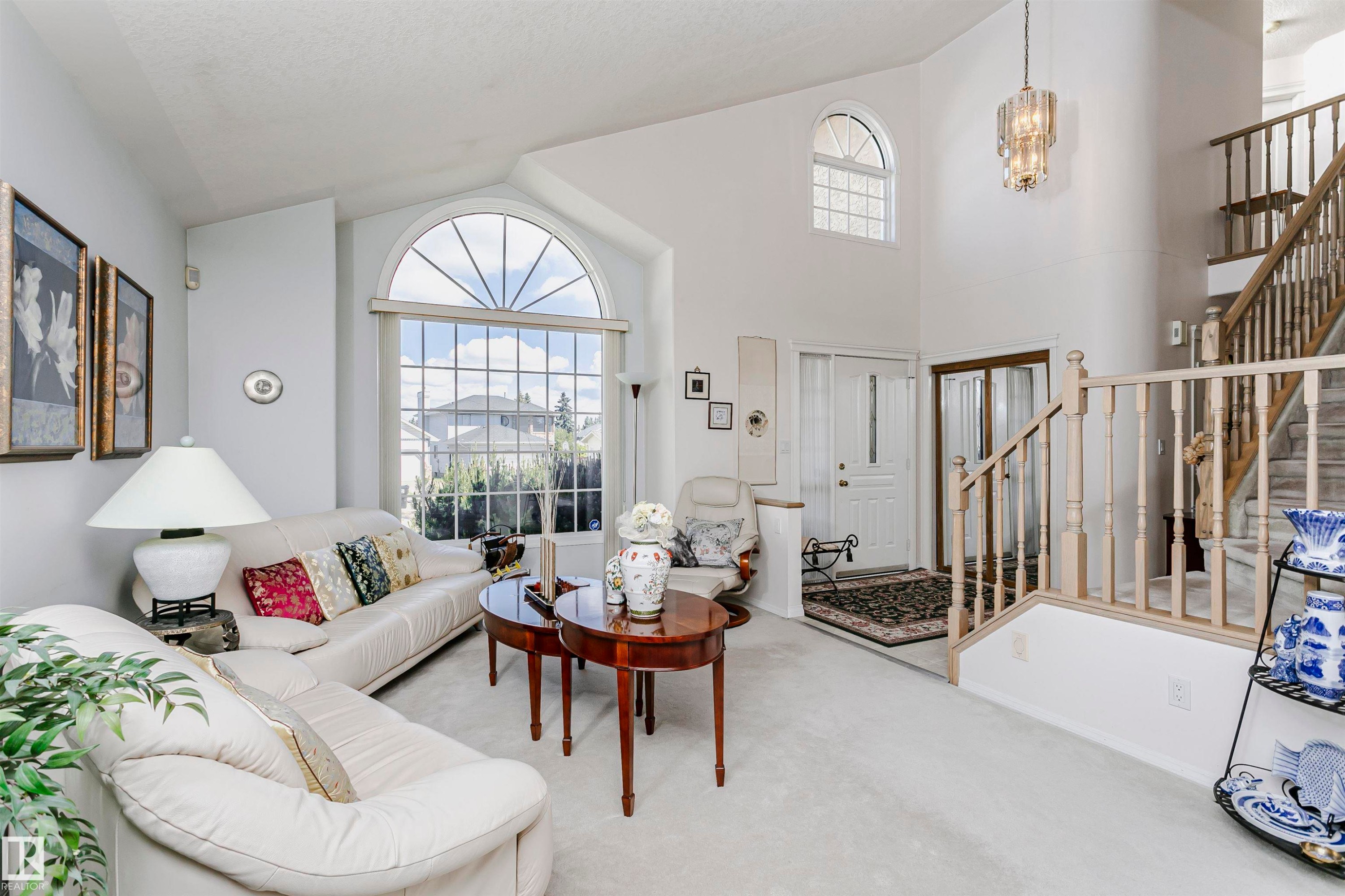 Two-story foyer with a grand staircase and light wood banisters - 11023 11A Avenue Nw, Edmonton, AB - Indoor