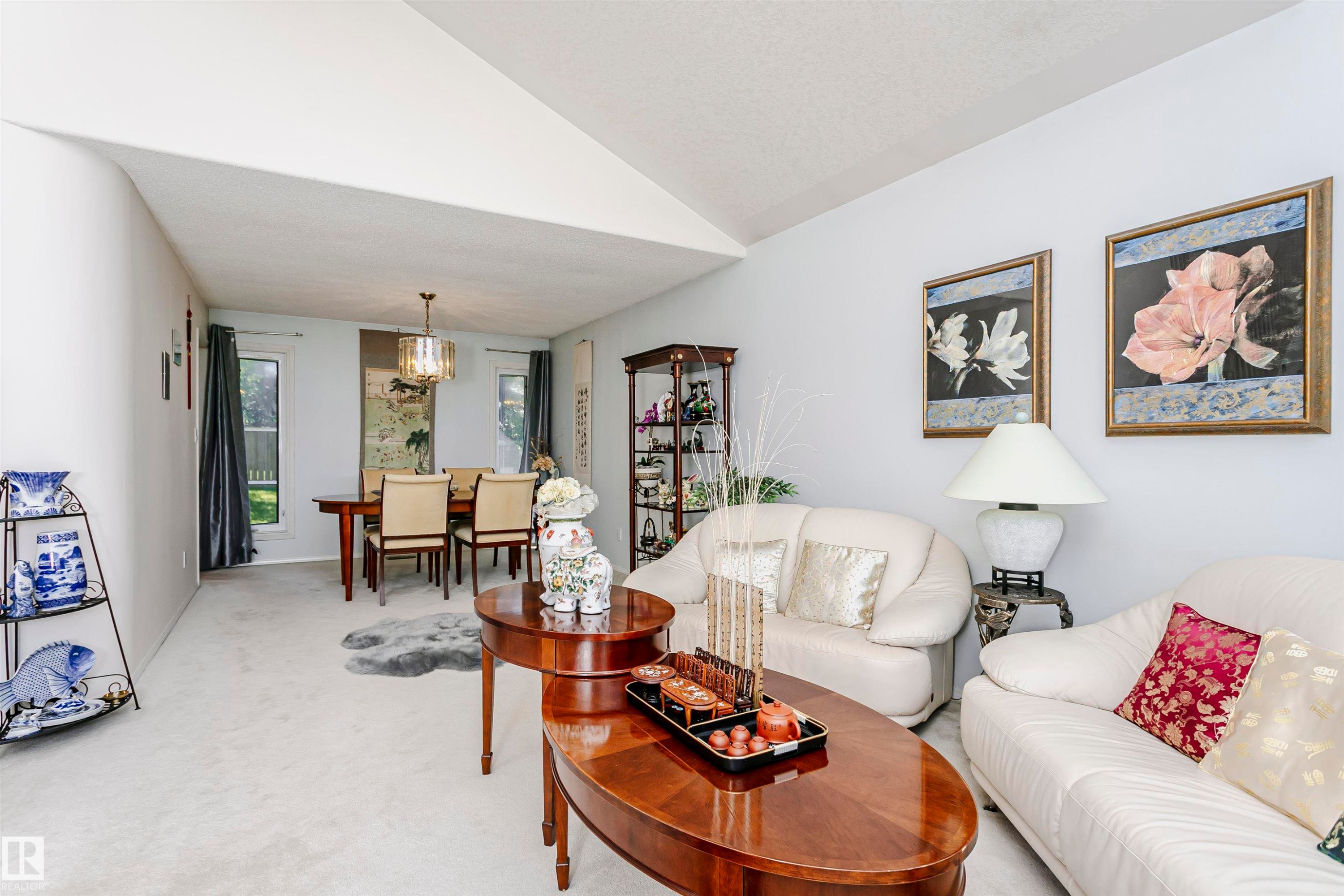 Open-concept living and dining area featuring vaulted ceilings, light wall tones, and carpet flooring - 11023 11A Avenue Nw, Edmonton, AB - Indoor Photo Showing Living Room