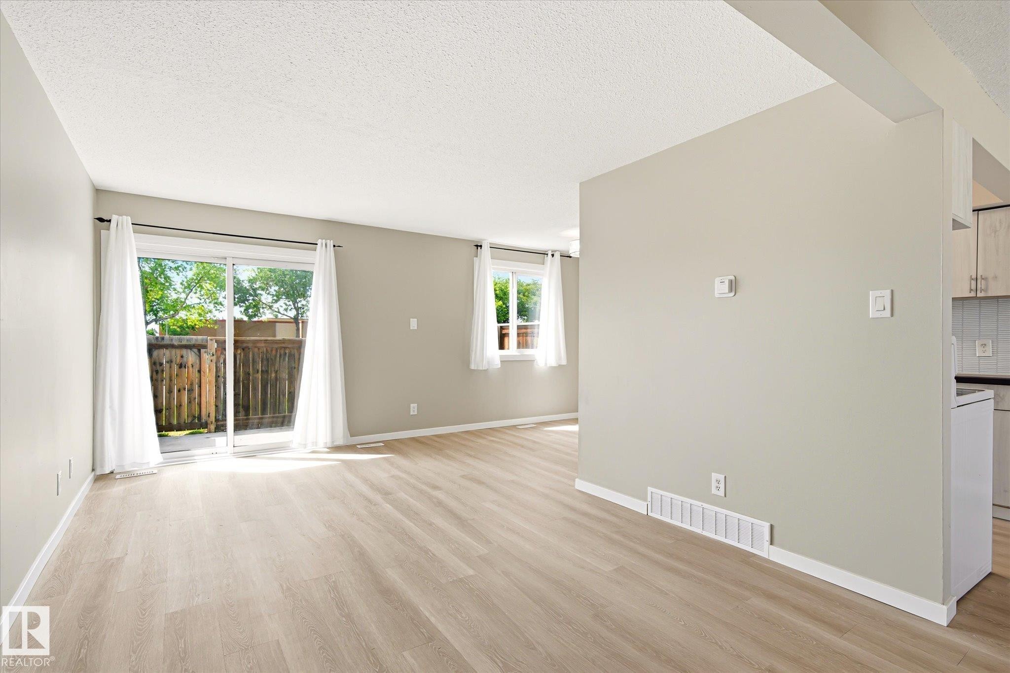 Spacious living area featuring light wood-finish flooring and neutral painted walls - 186 Cornell Crest, Edmonton, AB