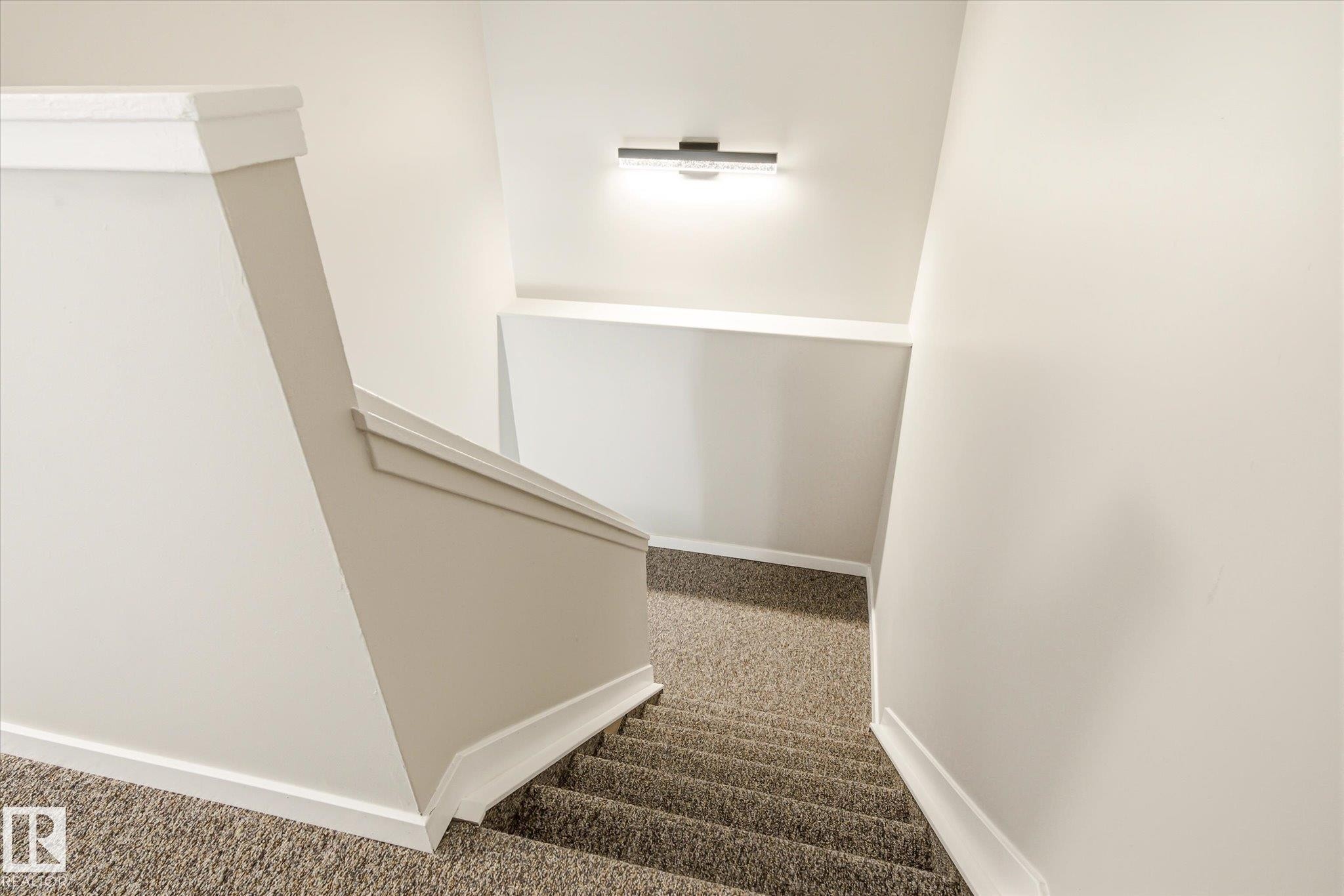 Carpeted staircase with light-toned walls - 186 Cornell Crest, Edmonton, AB