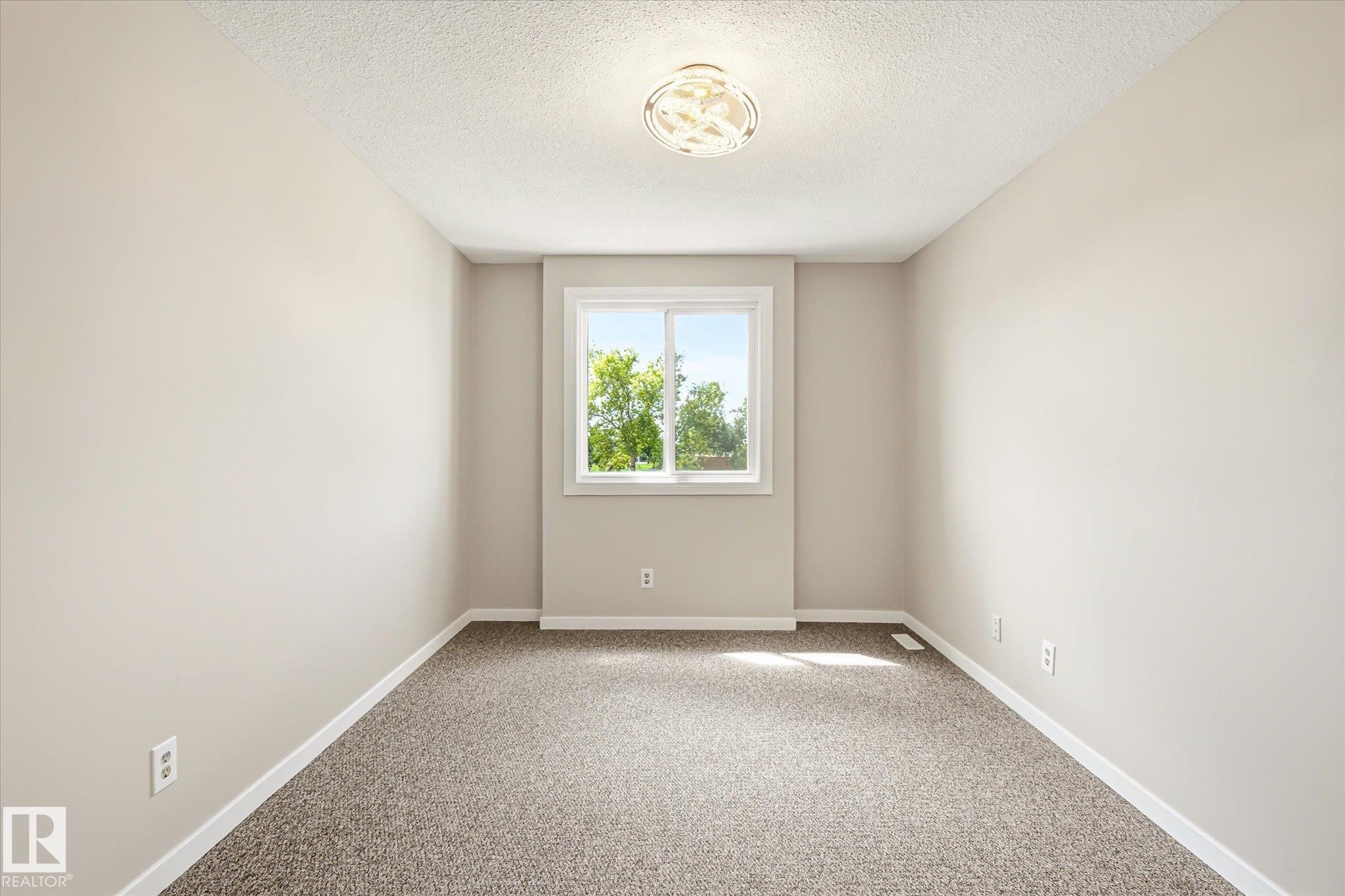 Neutral-toned interior room with textured carpeting, white trim, and a double-pane window - 186 Cornell Crest, Edmonton, AB