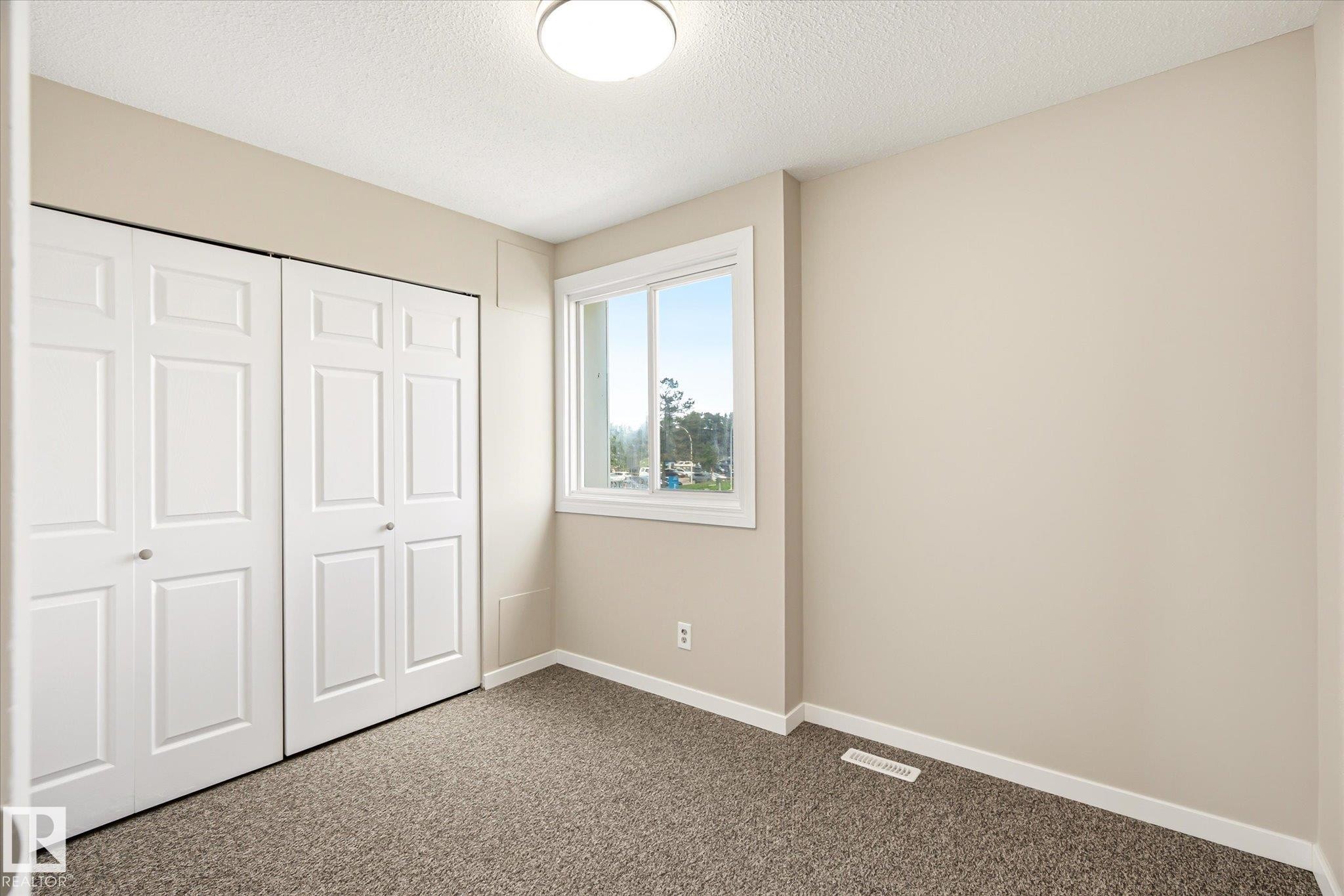 Bedroom featuring neutral-toned walls, white trim, and a window with white casing - 186 Cornell Crest, Edmonton, AB