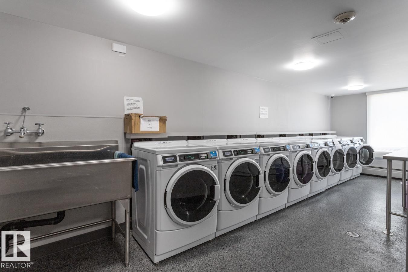 Building laundry room featuring multiple washing machines and dryers. There are multiple floors with laundry rooms - get more loads done at once! - 602 12303 Jasper Avenue, Edmonton, AB