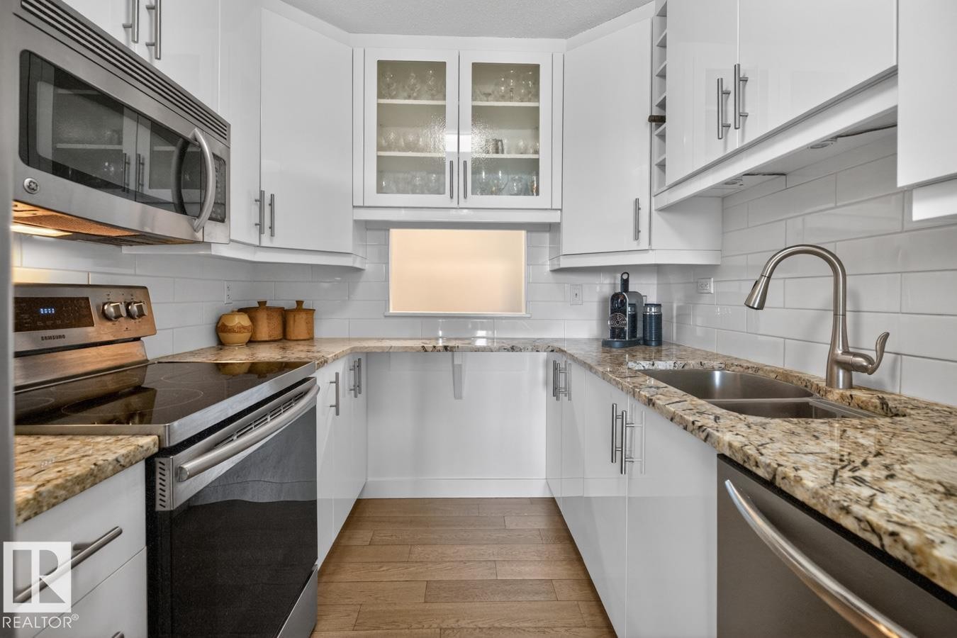 Updated White Kitchen Cabinets with Granite Counter Tops and Stainless Steel Appliances. Pass through window next to your front entrance makes dropping off groceries a breeze! - 602 12303 Jasper Avenue, Edmonton, AB