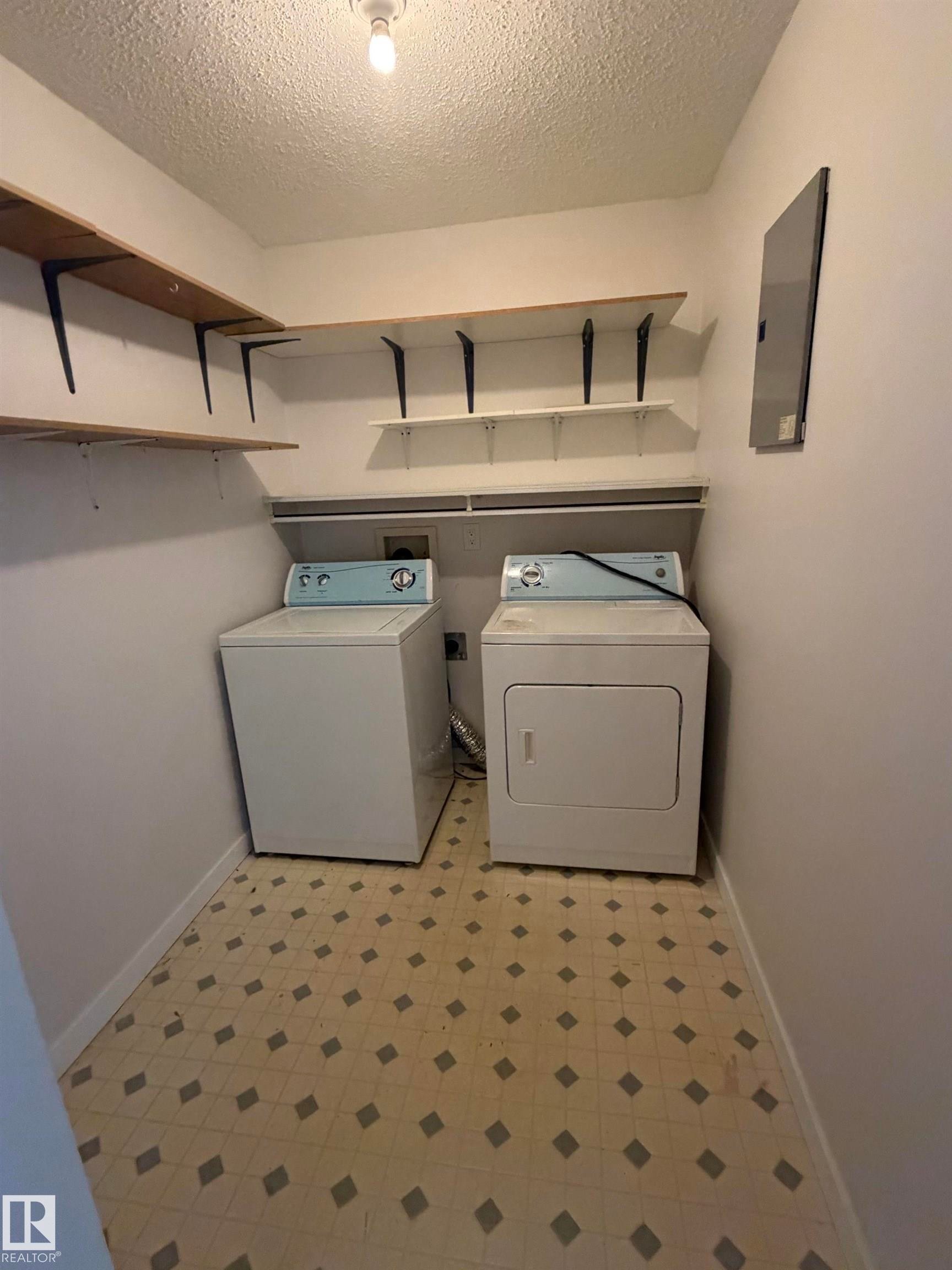 Utility room featuring a patterned floor, built-in shelving, and a ceiling-mounted light fixture - 213 17467 98A Avenue, Edmonton, AB