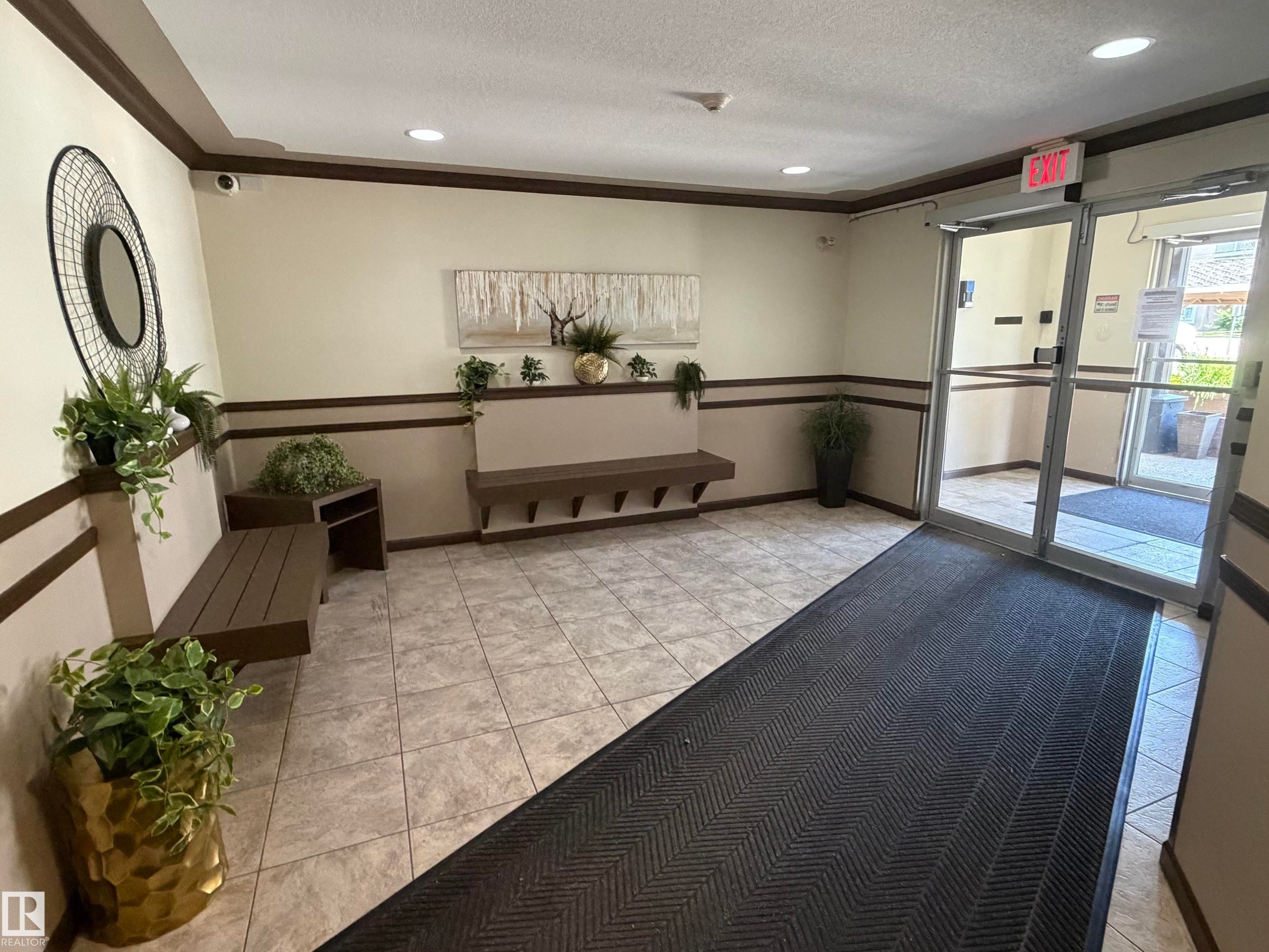 Tile flooring entryway with recessed lighting, glass doors, and two built-in benches - 213 17467 98A Avenue, Edmonton, AB