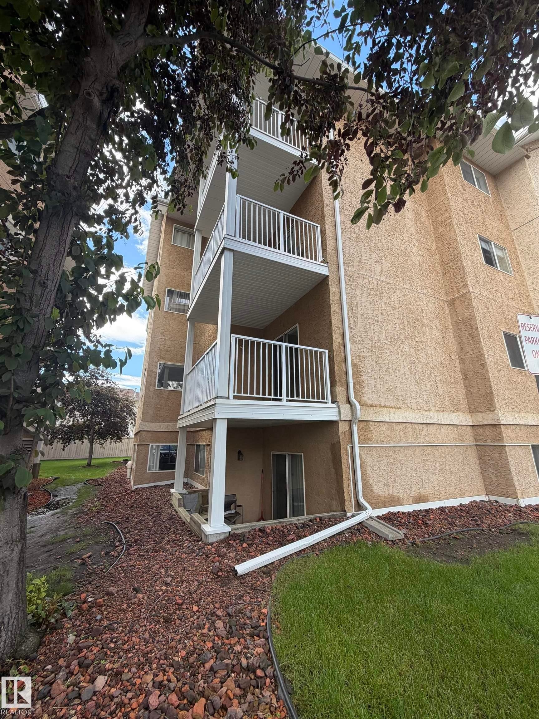 Multi-story building featuring stucco exterior and individual balconies with white railings - 213 17467 98A Avenue, Edmonton, AB