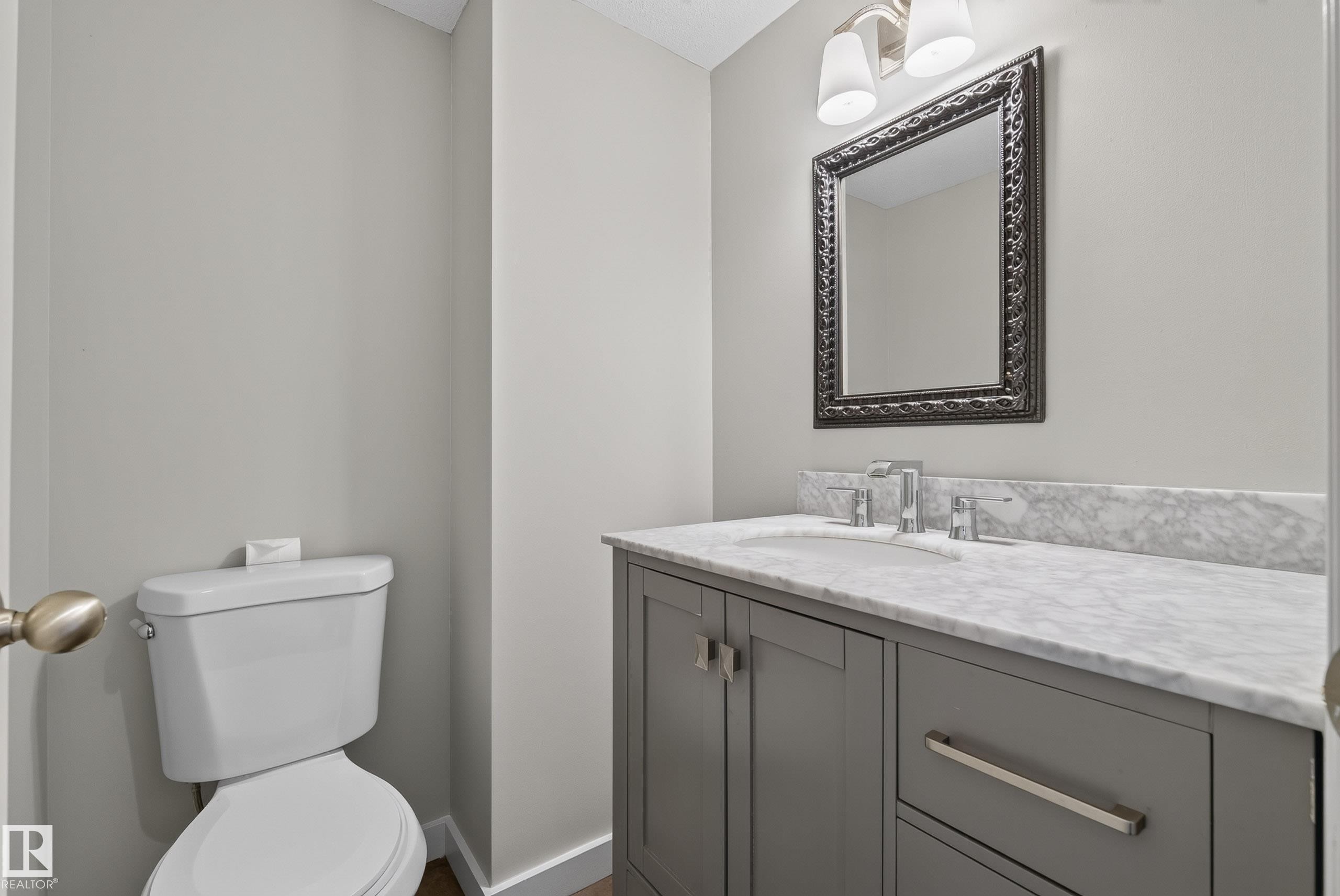 Modern vanity with gray cabinetry, brushed nickel hardware, and an integrated sink - 2712 104 Street, Edmonton, AB