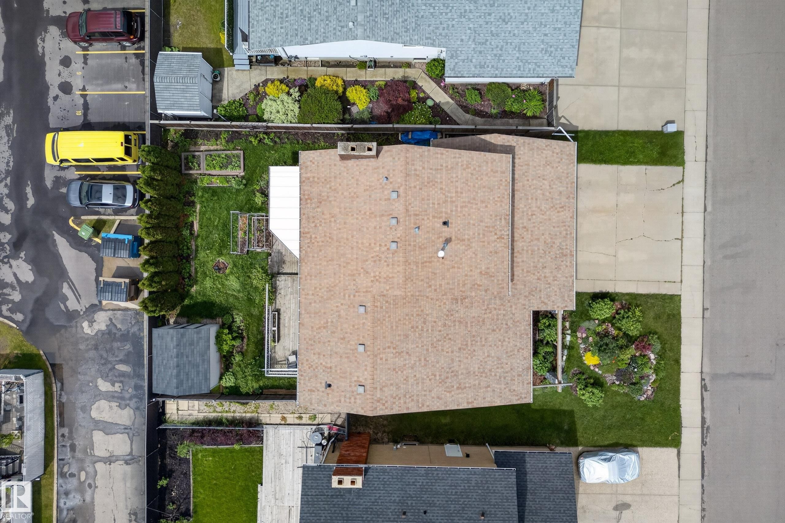 Aerial view showcasing a property with a light-colored shingle roof, green lawn areas, and established garden beds - 2712 104 Street, Edmonton, AB