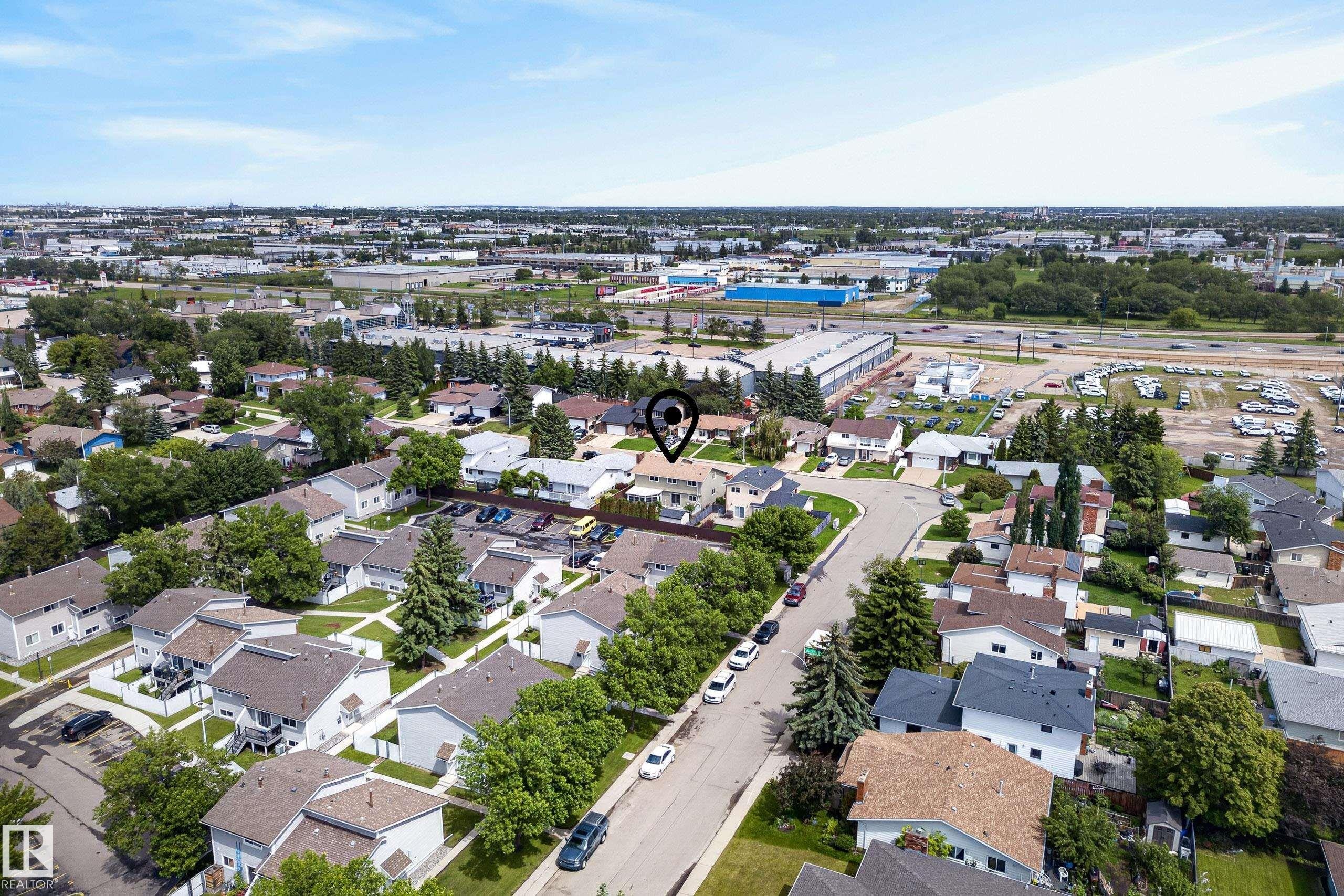 Aerial perspective of a residential community featuring numerous single-family homes with pitched roofs, mature trees, and paved streets - 2712 104 Street, Edmonton, AB