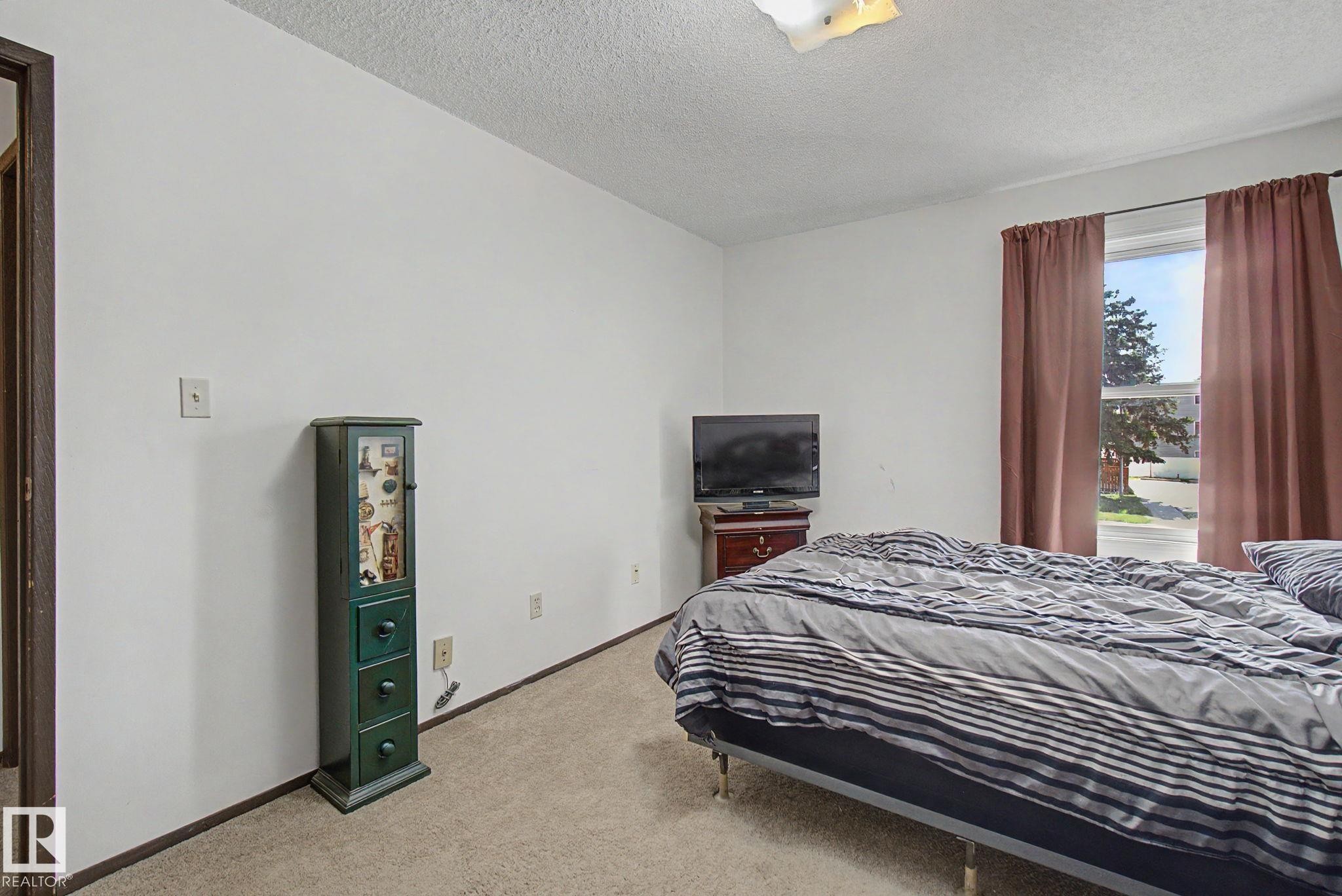 Bedroom featuring beige carpet flooring and white painted walls - 18409 66 Avenue, Edmonton, AB