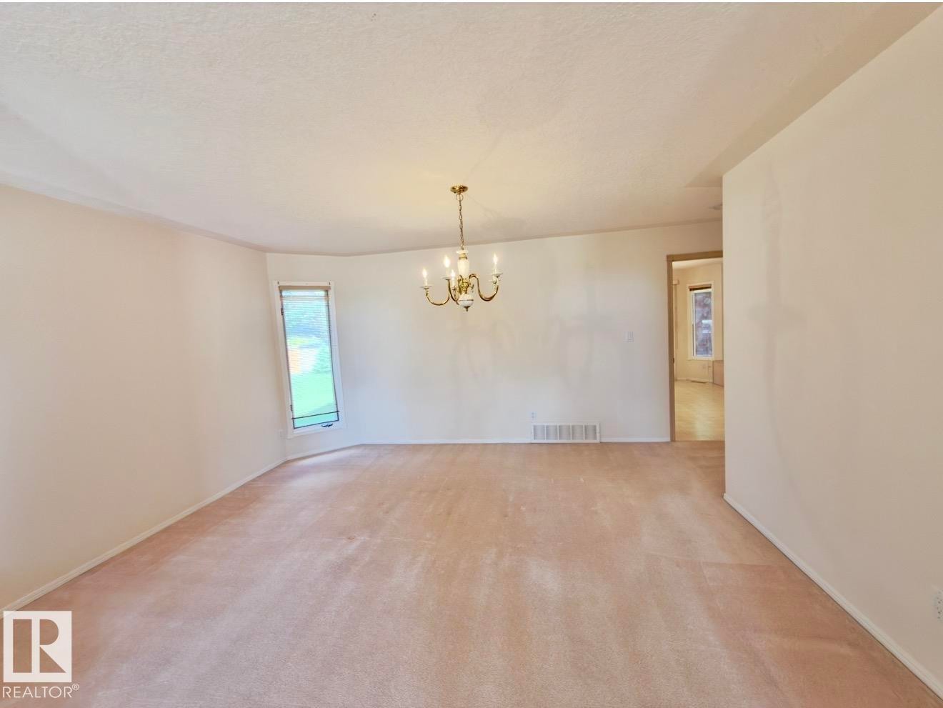 Spacious interior room with light-toned wall finishes and wall-to-wall carpeting - 134 Wolf Ridge Place, Edmonton, AB