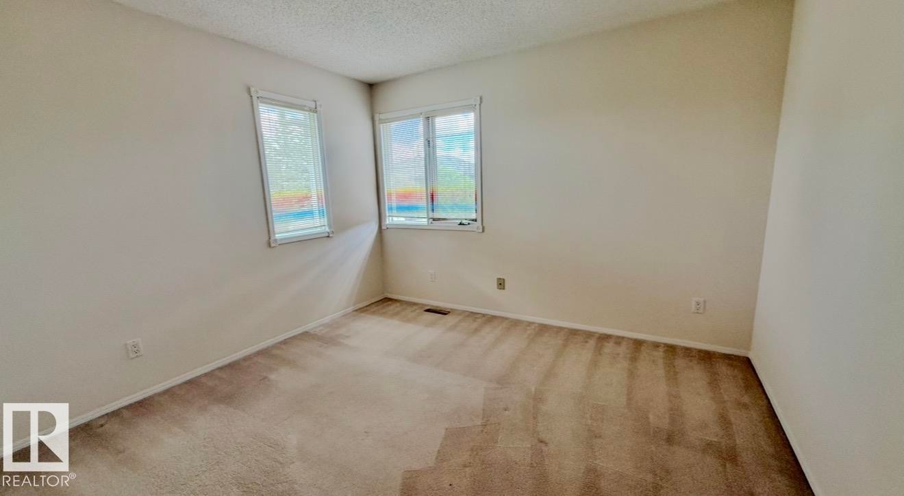 Carpeted interior space with neutral wall tones and a textured ceiling - 134 Wolf Ridge Place, Edmonton, AB