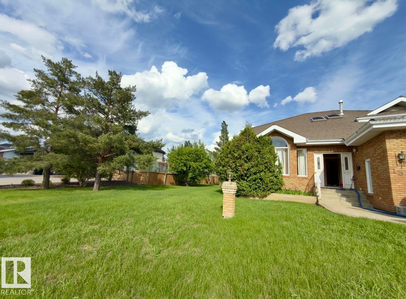 Brick exterior residence featuring an arched window, white trim, and skylights - 134 Wolf Ridge Place, Edmonton, AB