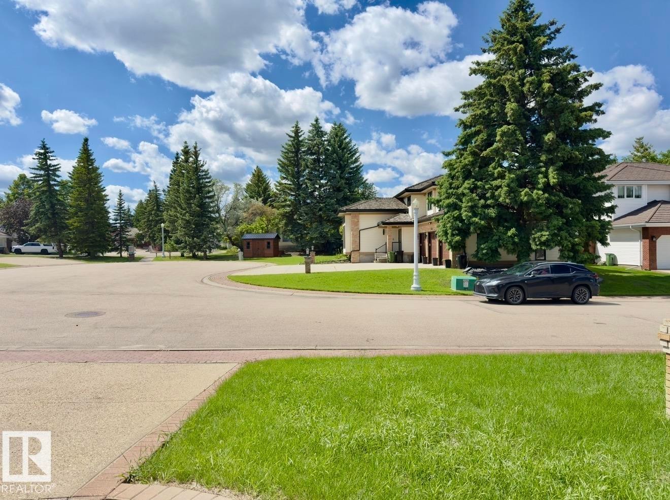 Manicured lawn with a concrete walkway and brick border - 134 Wolf Ridge Place, Edmonton, AB