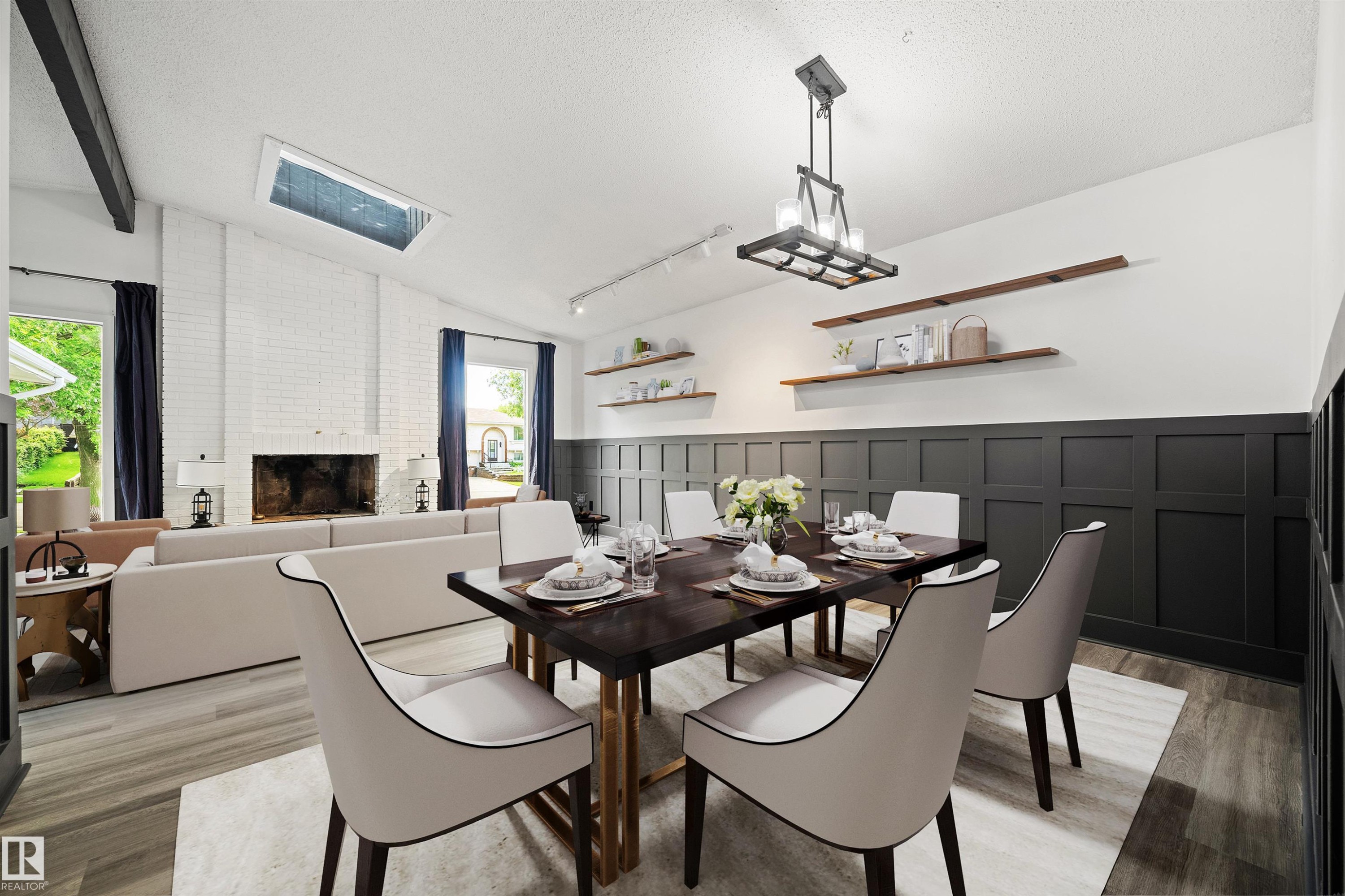 Open-concept living and dining area featuring vaulted ceilings with exposed beams, a skylight, a white brick fireplace, wood-finish flooring, and wainscoting paneling - 28 Goodridge Drive, St. Albert, AB