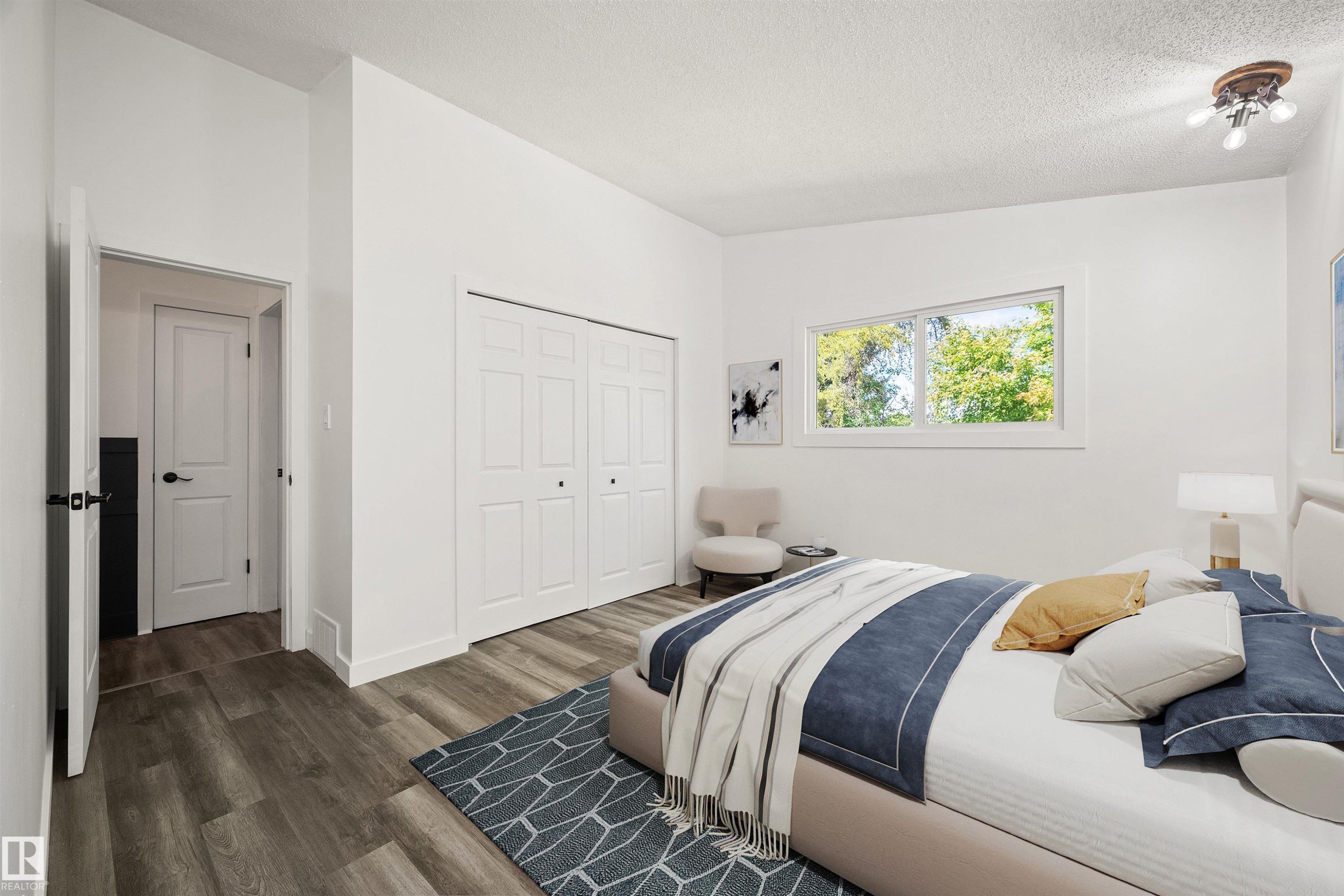 Spacious room featuring wood-finish flooring, white walls, and a large window - 28 Goodridge Drive, St. Albert, AB