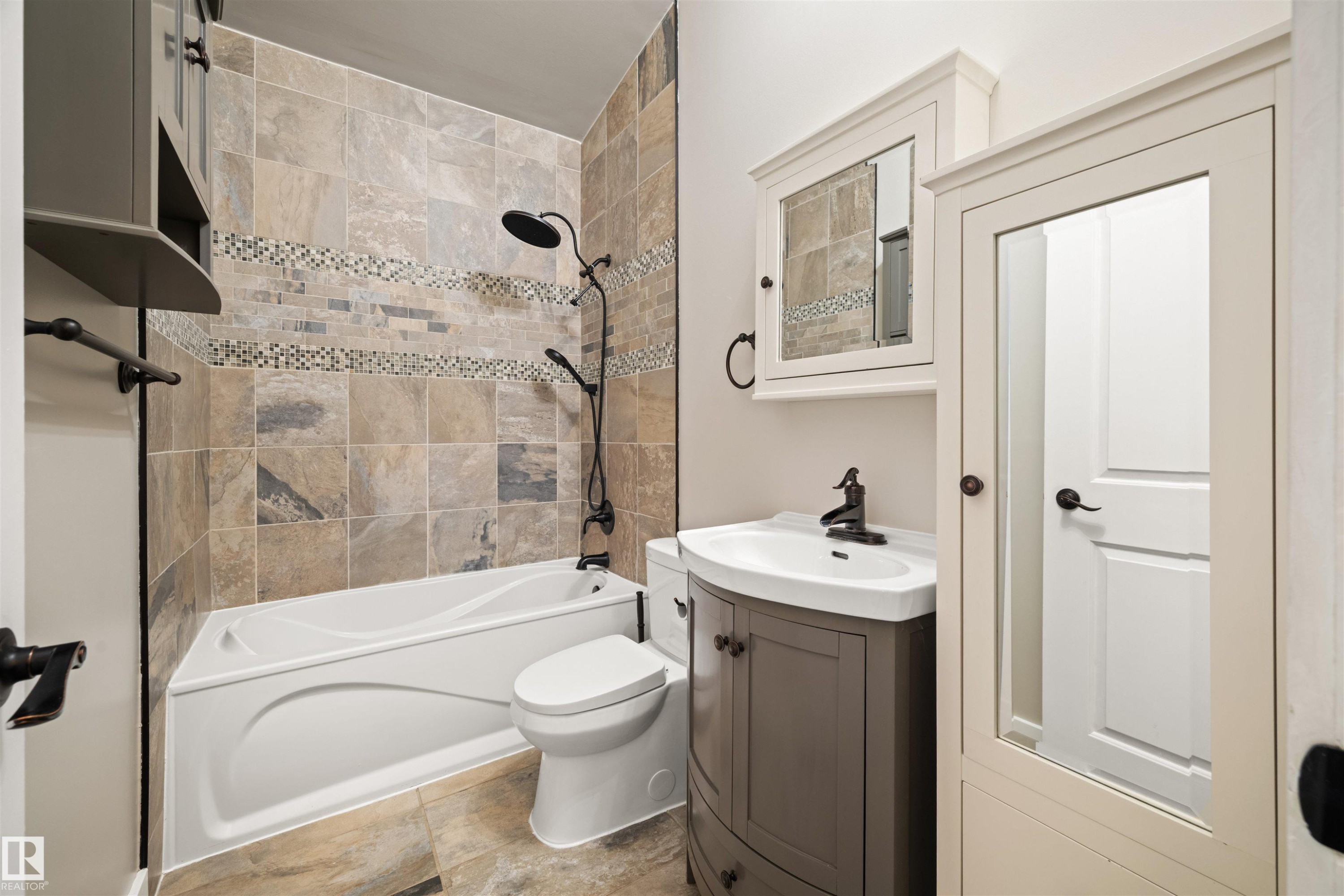 Bathroom featuring a white bathtub, toilet, and a vanity with an integrated sink - 28 Goodridge Drive, St. Albert, AB