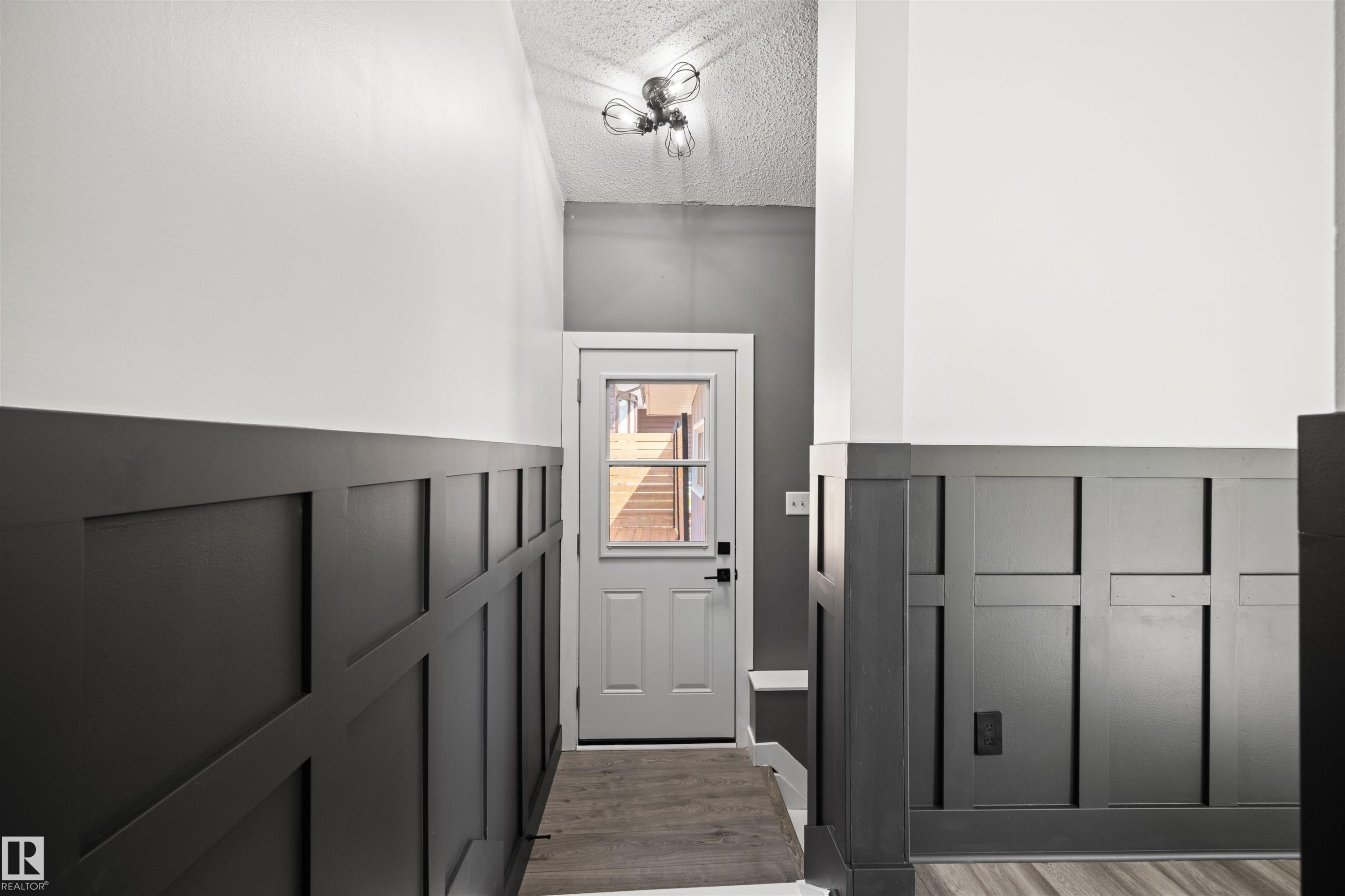 Entryway featuring dark wainscoting and light-toned walls - 28 Goodridge Drive, St. Albert, AB