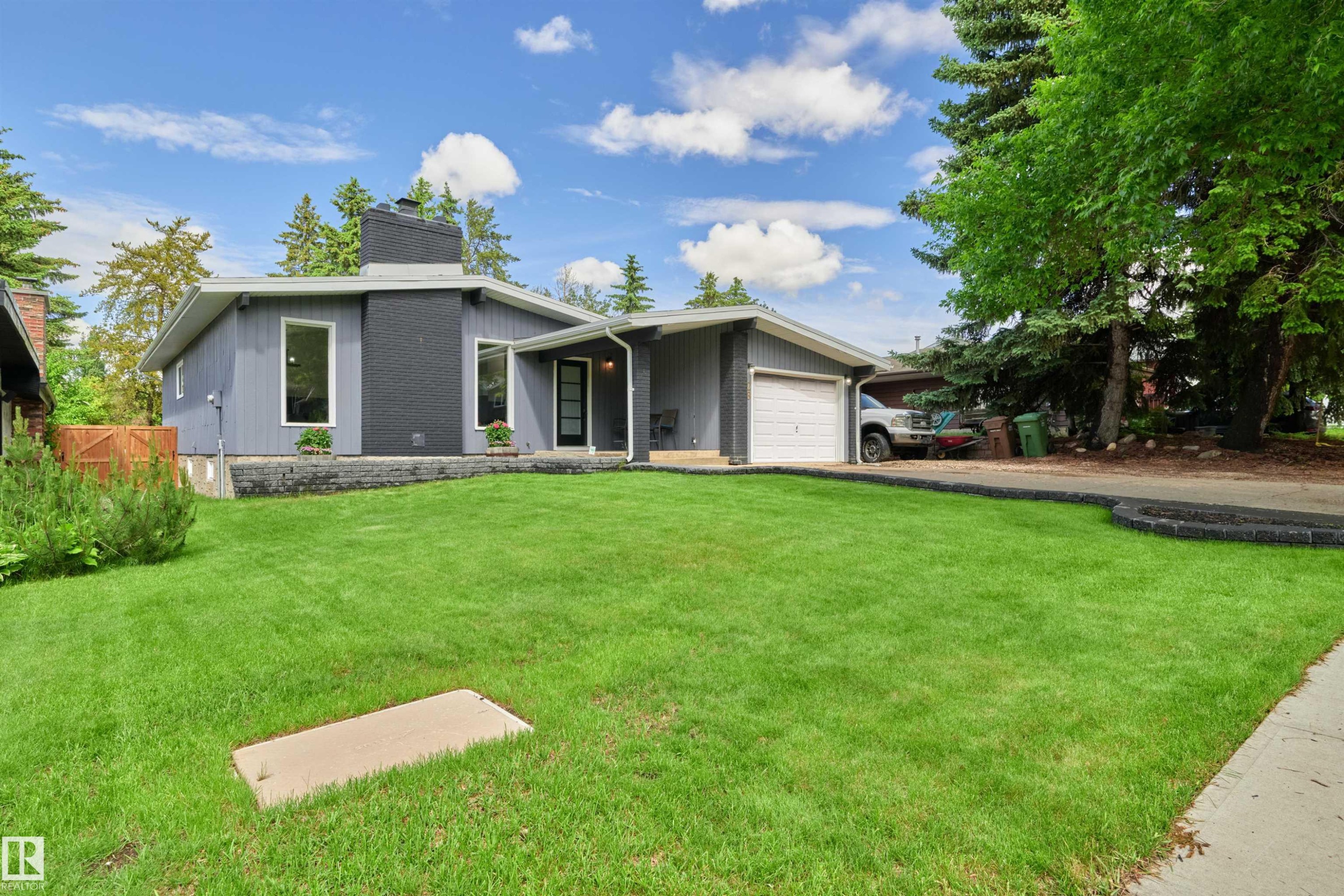 Contemporary single-story residence featuring a striking dark gray facade and a light gray exterior - 28 Goodridge Drive, St. Albert, AB
