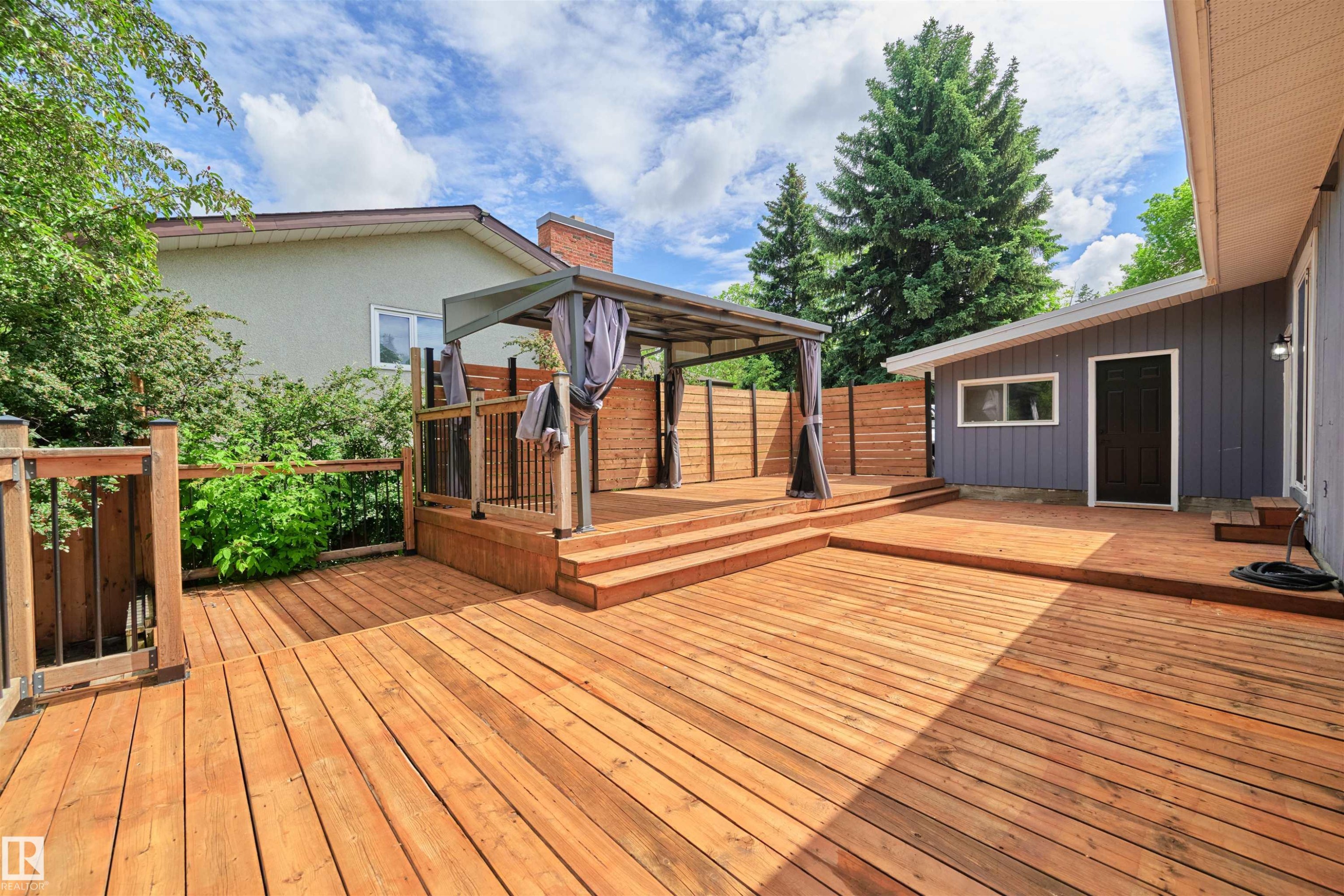 Multi-level wood deck featuring a covered gazebo, integrated privacy screen, and exterior access to the property - 28 Goodridge Drive, St. Albert, AB
