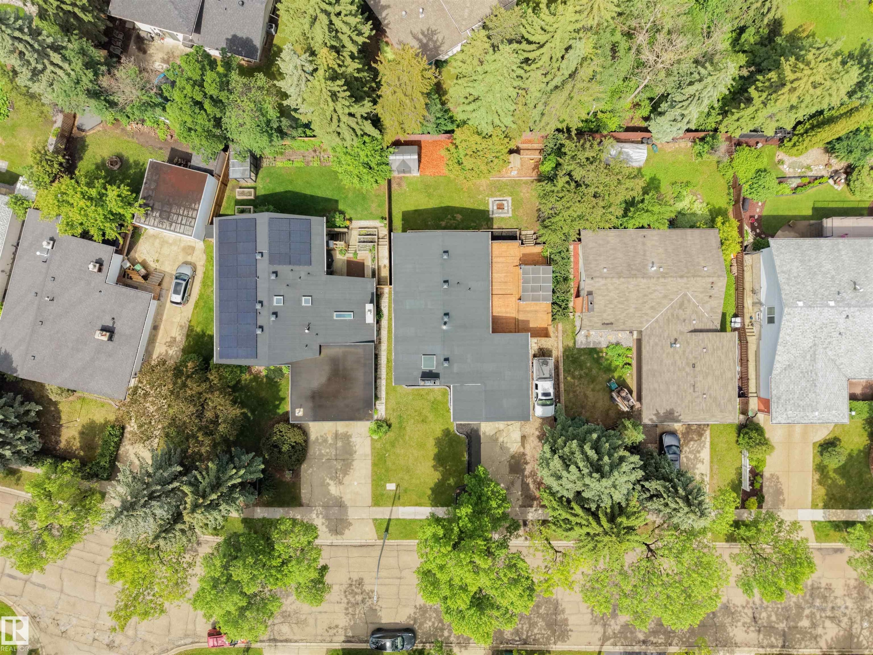 Aerial perspective of a property featuring a dark-toned roof with integrated solar panels - 28 Goodridge Drive, St. Albert, AB