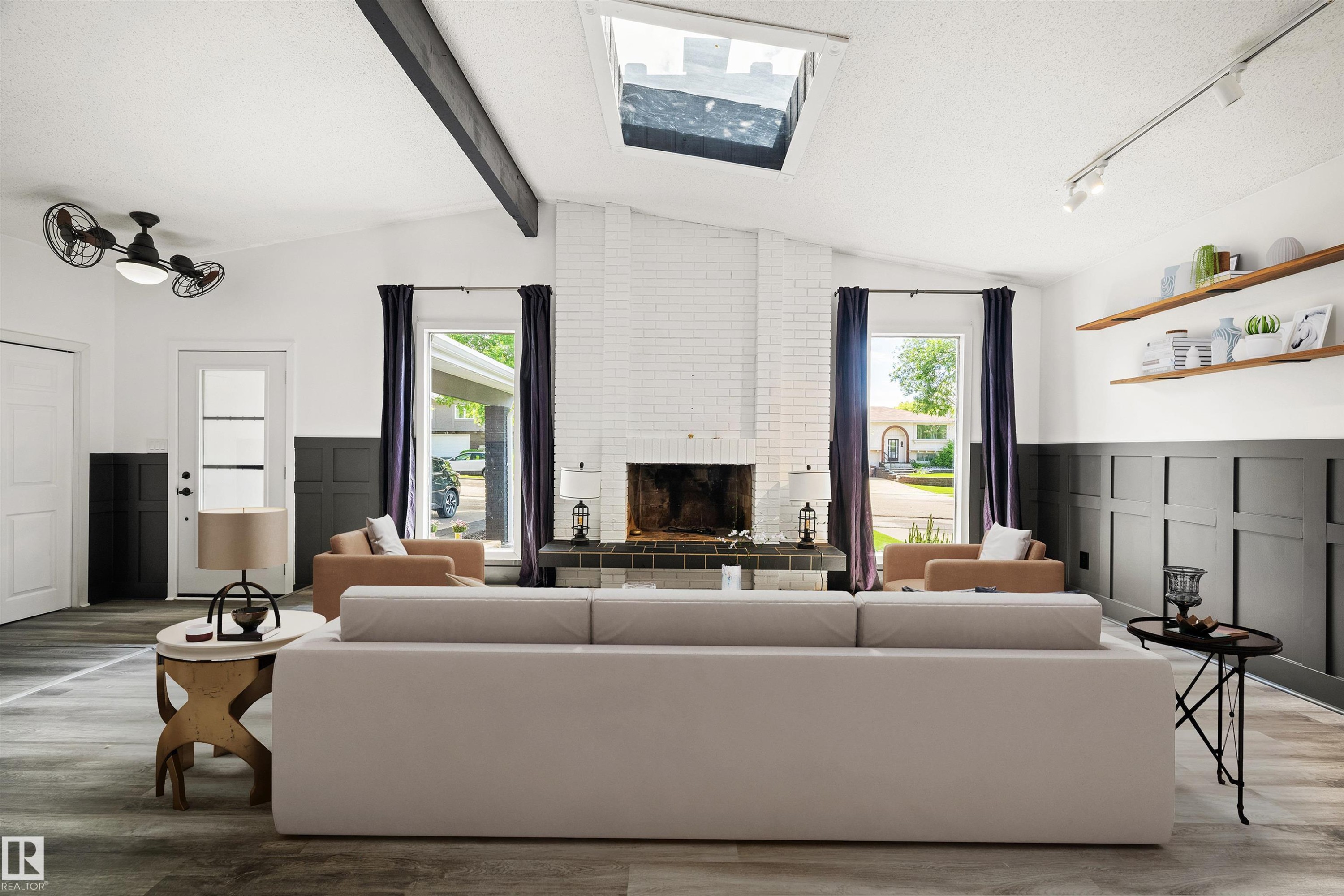 Vaulted ceiling with exposed beam, white brick fireplace with dark tile hearth, and wood-finish flooring - 28 Goodridge Drive, St. Albert, AB