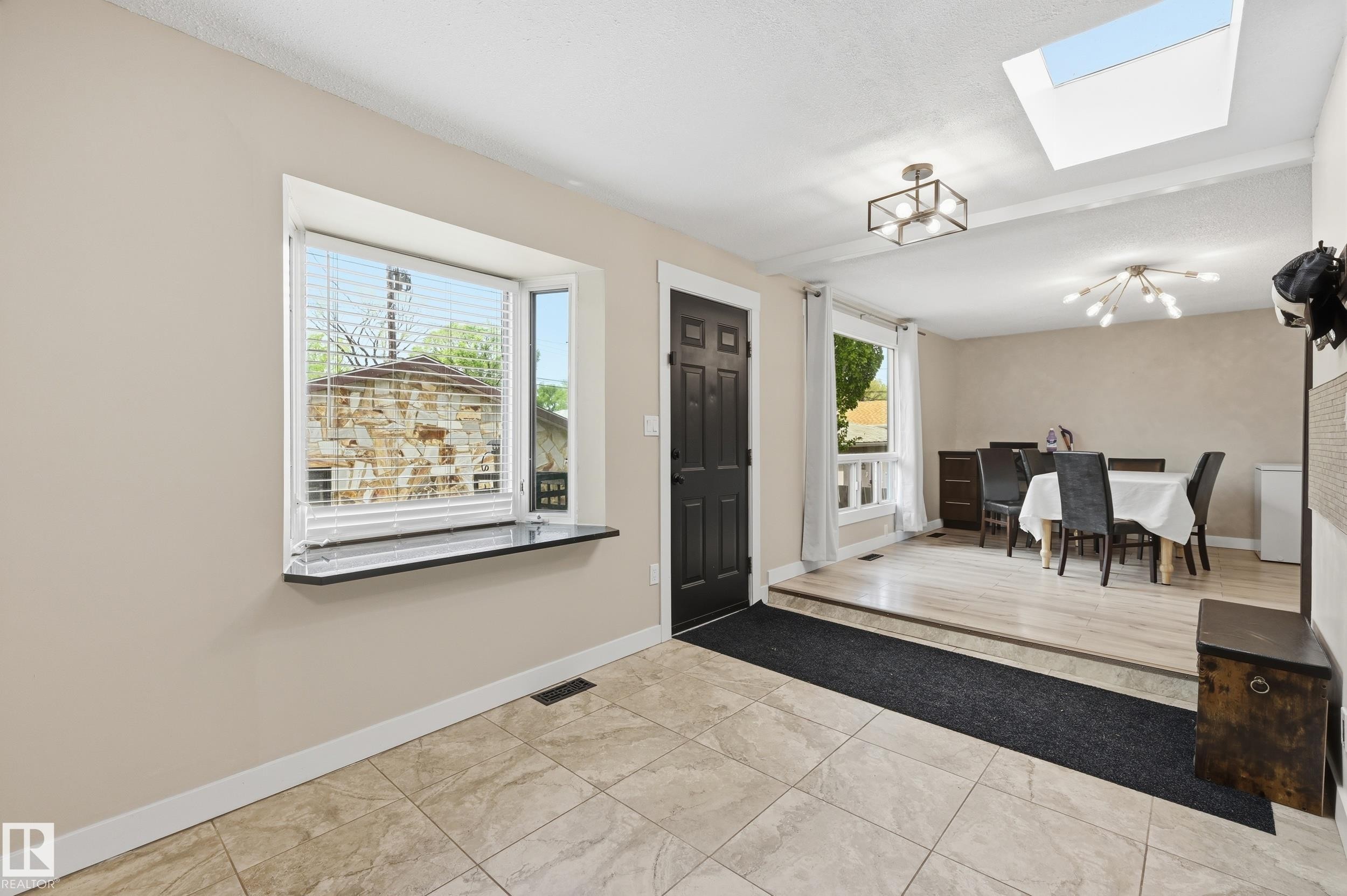 Foyer with neutral-toned tiled flooring and a dark paneled entry door - 12326 92 Street, Edmonton, AB - Indoor Photo Showing Other Room