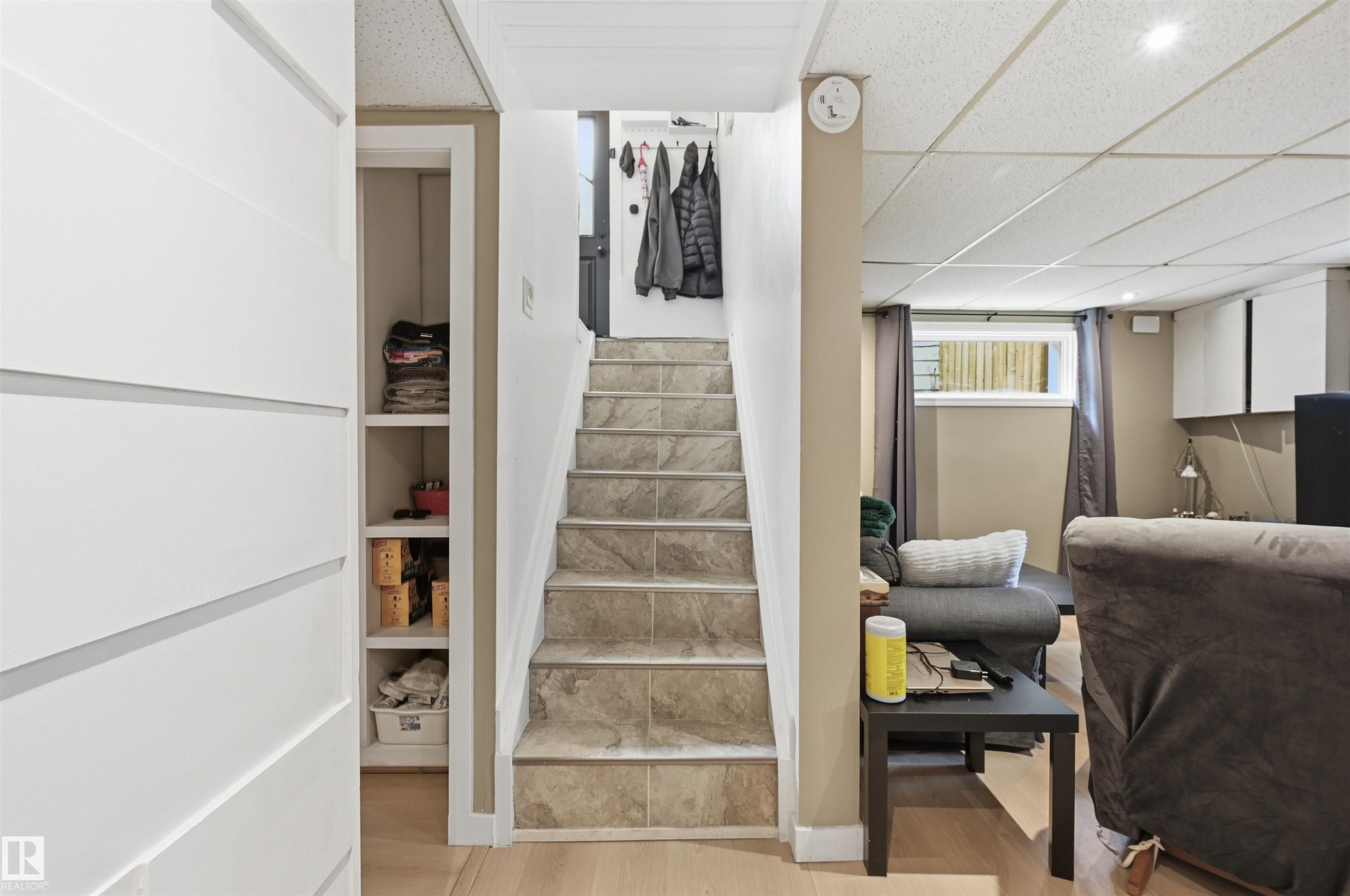 Staircase featuring tile treads, leading to an upper level with light wood-finish flooring - 12326 92 Street, Edmonton, AB - Indoor Photo Showing Other Room