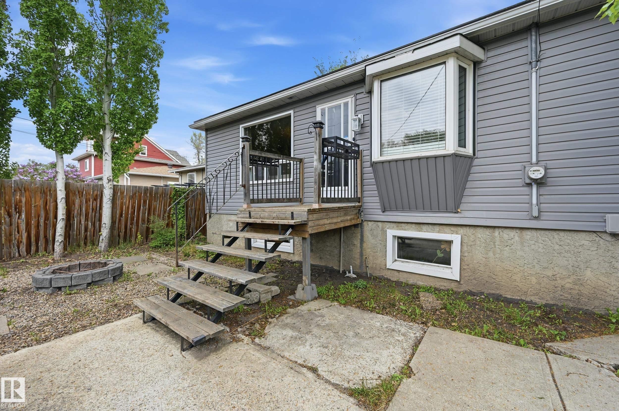 Gray siding exterior with a bay window and a rectangular basement window - 12326 92 Street, Edmonton, AB - Outdoor
