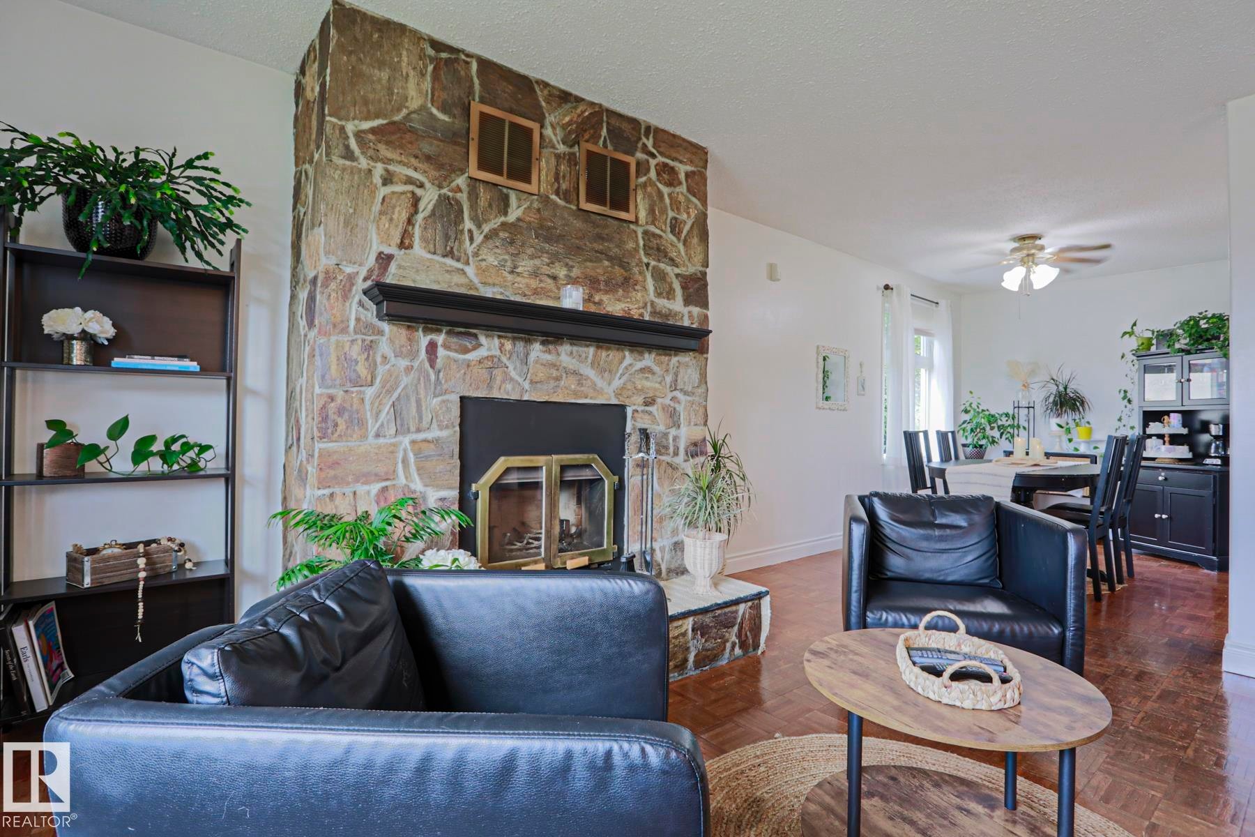 Floor-to-ceiling stone fireplace featuring a black mantel - 2007 67 Street, Edmonton, AB