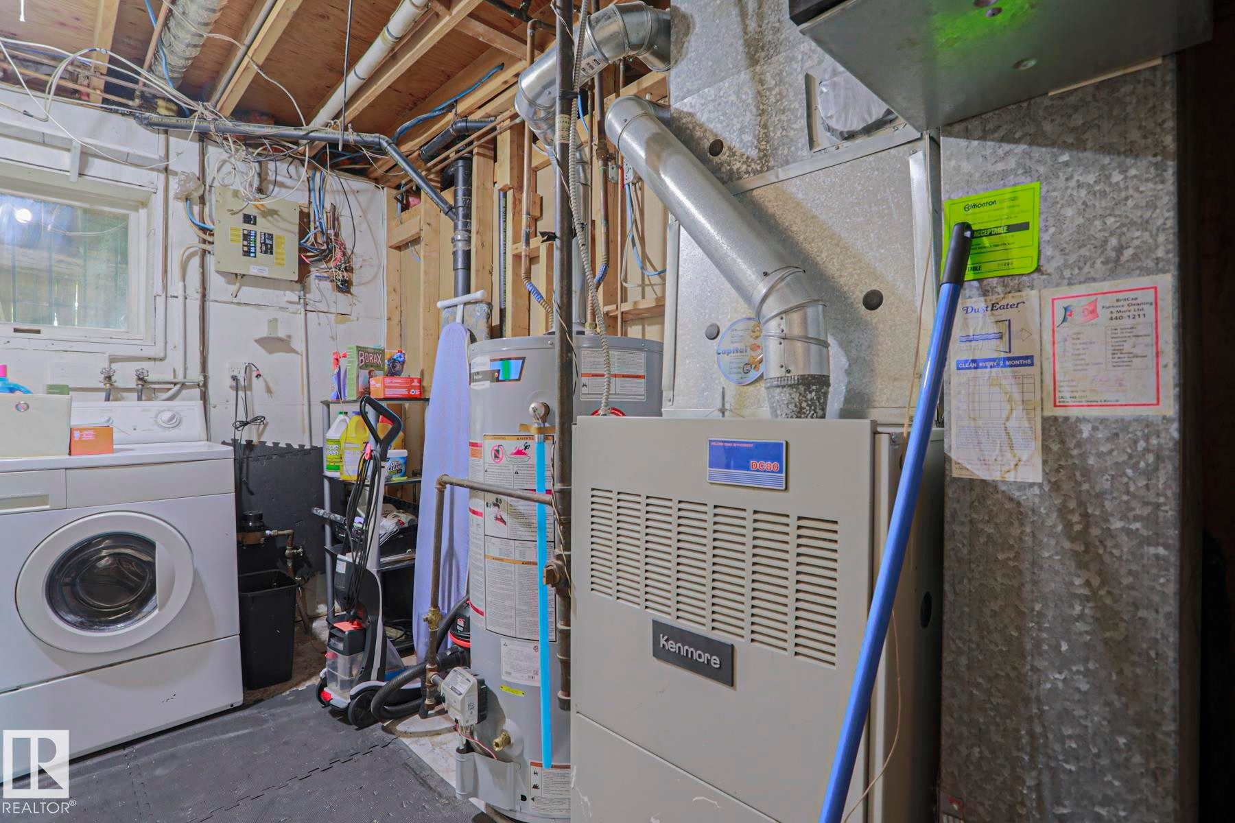 Utility area featuring a water heater, furnace, and exposed ceiling joists - 2007 67 Street, Edmonton, AB